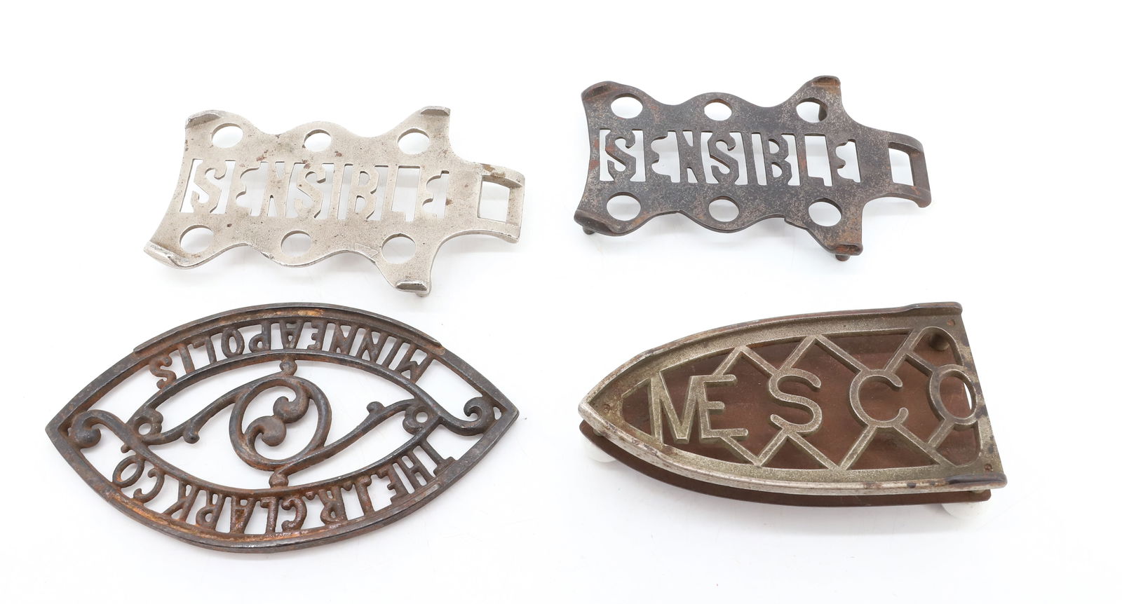 (4) ANTIQUE TRIVETS: INCLUDING: MESCO, THE J.R. CLARK CO. AND TWO SENSIBLE. 6" TO 7" L. PLEASE READ CAREFULLY - Terms for Purchasing and Shipping of Auction Items. Please read carefully before bidding. THIS IS AN ONSITE A