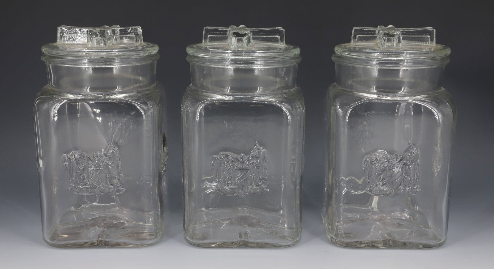 (3) HUDSON BAY EMBOSSED JARS: EMBOSSED DECORATION ON THREE SIDES. ALL WITH LIDS. 8 5/8" H. PLEASE READ CAREFULLY - Terms for Purchasing and Shipping of Auction Items. Please read carefully before bidding. Hartzell’s Auction