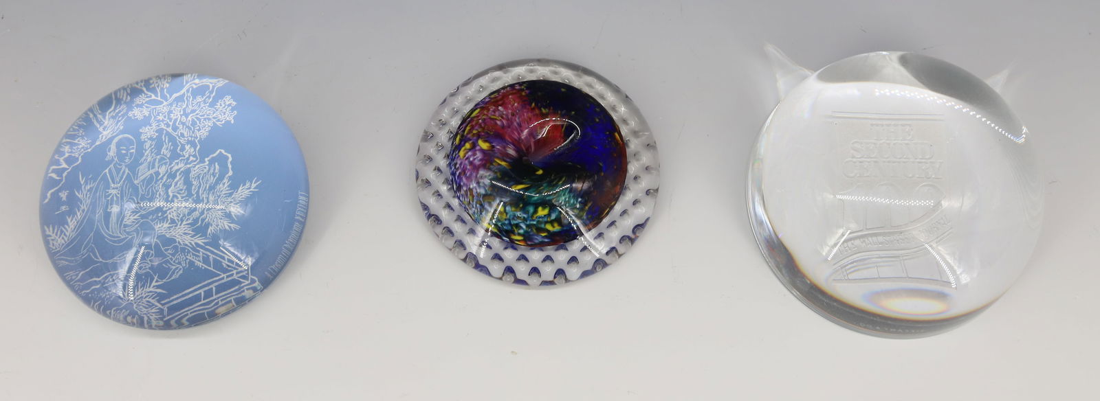 LOT OF (3) GLASS PAPERWEIGHTS: INCLUDING: TIFFANY & CO. "THE WALL STREET JOURNAL, THE SECOND CENTURY". 3 1/2" D. " A DREAM OF MANSIONS, KEYIART" 3 1/4" D. WITH, PAPERWEIGHT/PEN HOLDER. COLORFUL ART GLASS EXAMPLE WITH TEXTURED BASE.