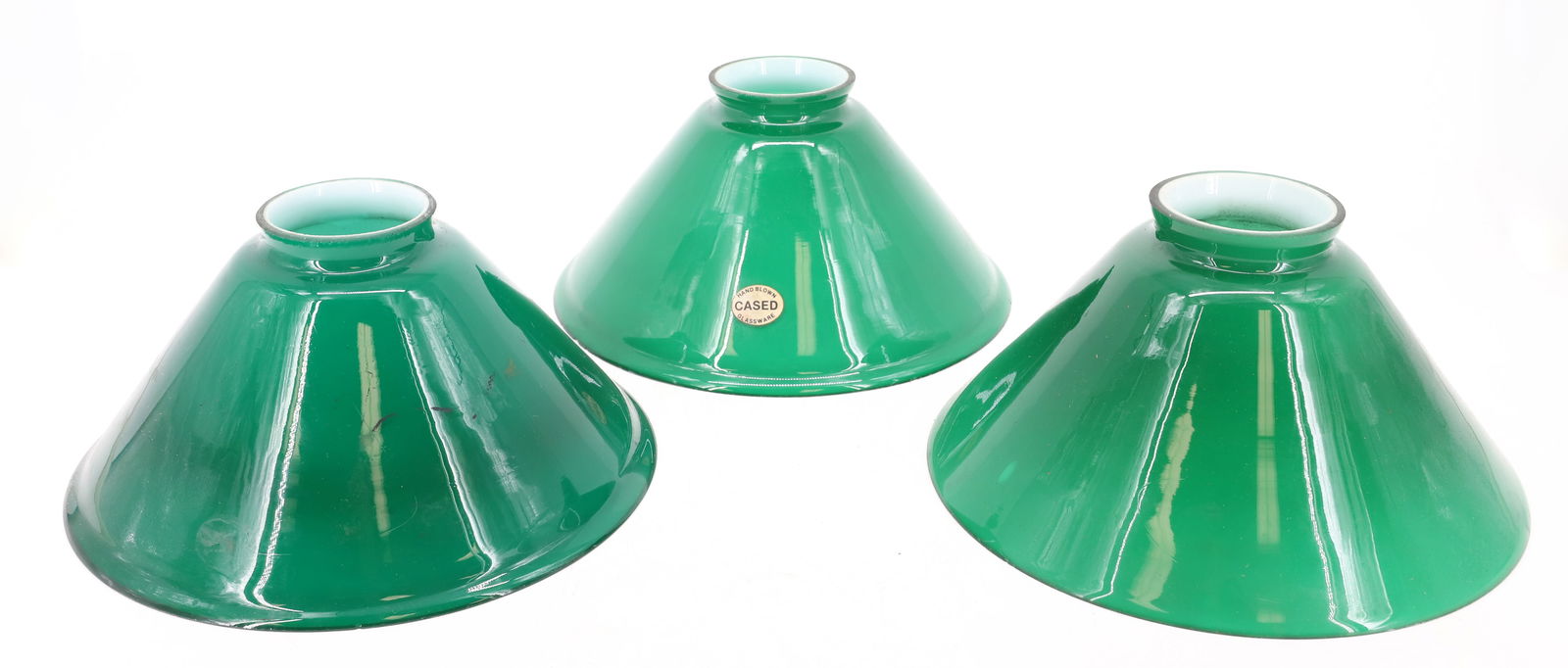 (3) VINTAGE EMERALD GREEN CASED SHADES: GREEN WITH WHITE INTERIORS. ONE WITH ORIGINAL STICKER. 10 1/4" DIAMETERS AT BOTTOM. TOP FITTER : ONE IS 2 7/8" AND TWO ARE 3 1/8". PLEASE READ CAREFULLY - Terms for Purchasing and Shipping of Auction