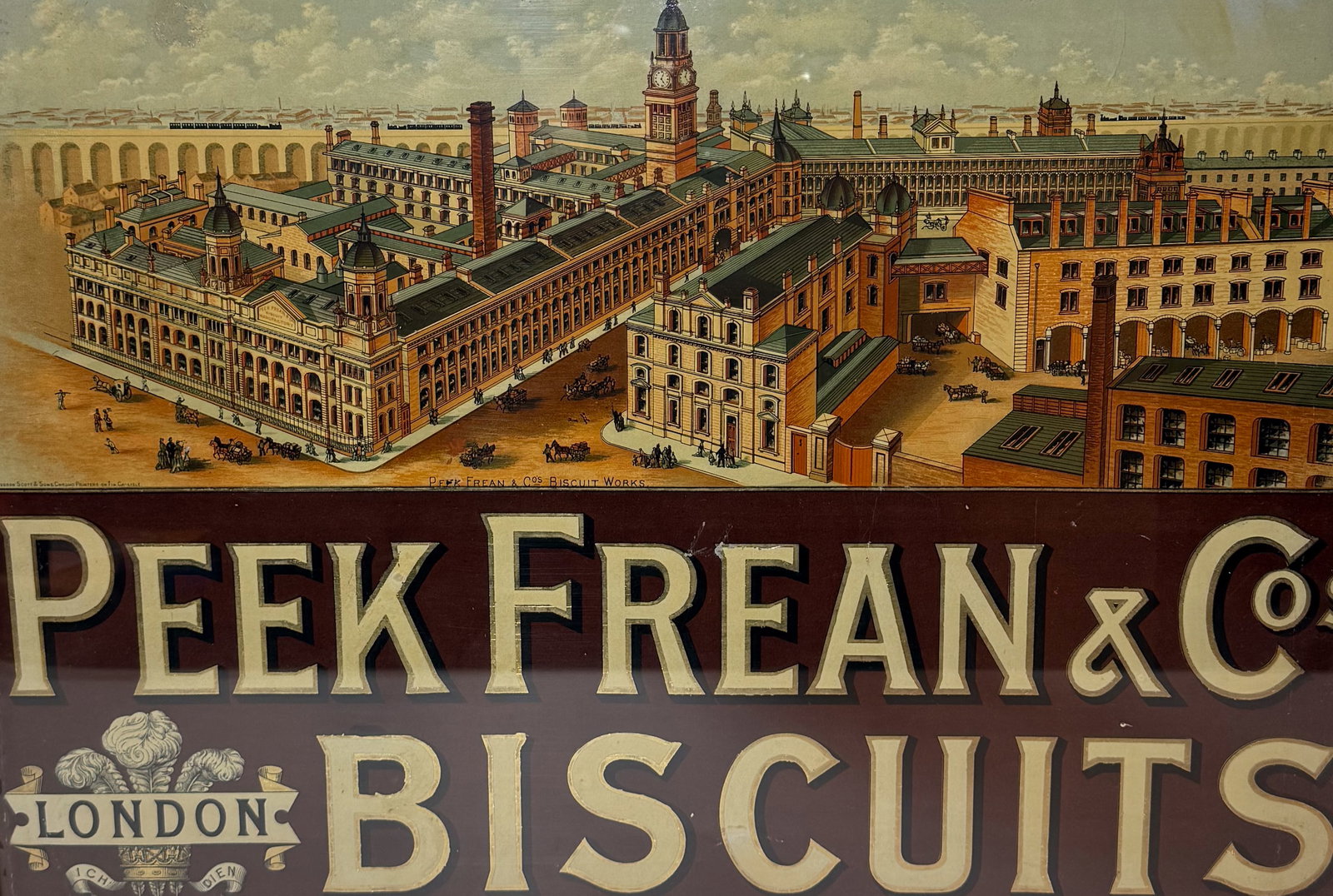 PEEK, FREAN & CO. ADVERTISING SIGN: "BISCUITS, LONDON". DEPICTING FACTORY. PAPER LITHO FRAMED UNDER GLASS. TOTAL SIZE 20" X 26 1/2". PLEASE READ CAREFULLY - THIS IS AN ONLINE ONSITE ONLY AUCTION - Terms for Purchasing and Shipping of Au