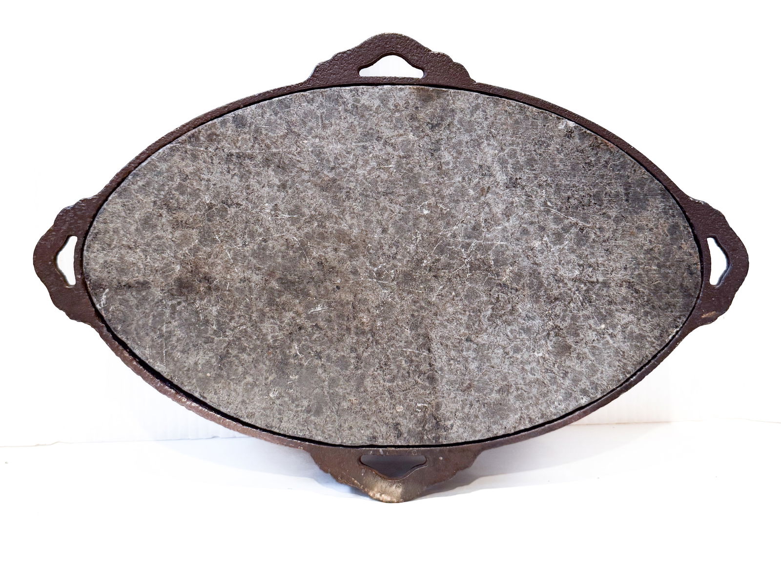 OVAL WARMING STONE: OVAL STONE FITTED TO CAST IRON SURROUND. 13 1/2" L. PLEASE READ CAREFULLY - THIS IS AN ONLINE ONSITE ONLY AUCTION - Terms for Purchasing and Shipping of Auction Items. Please read carefully before bid