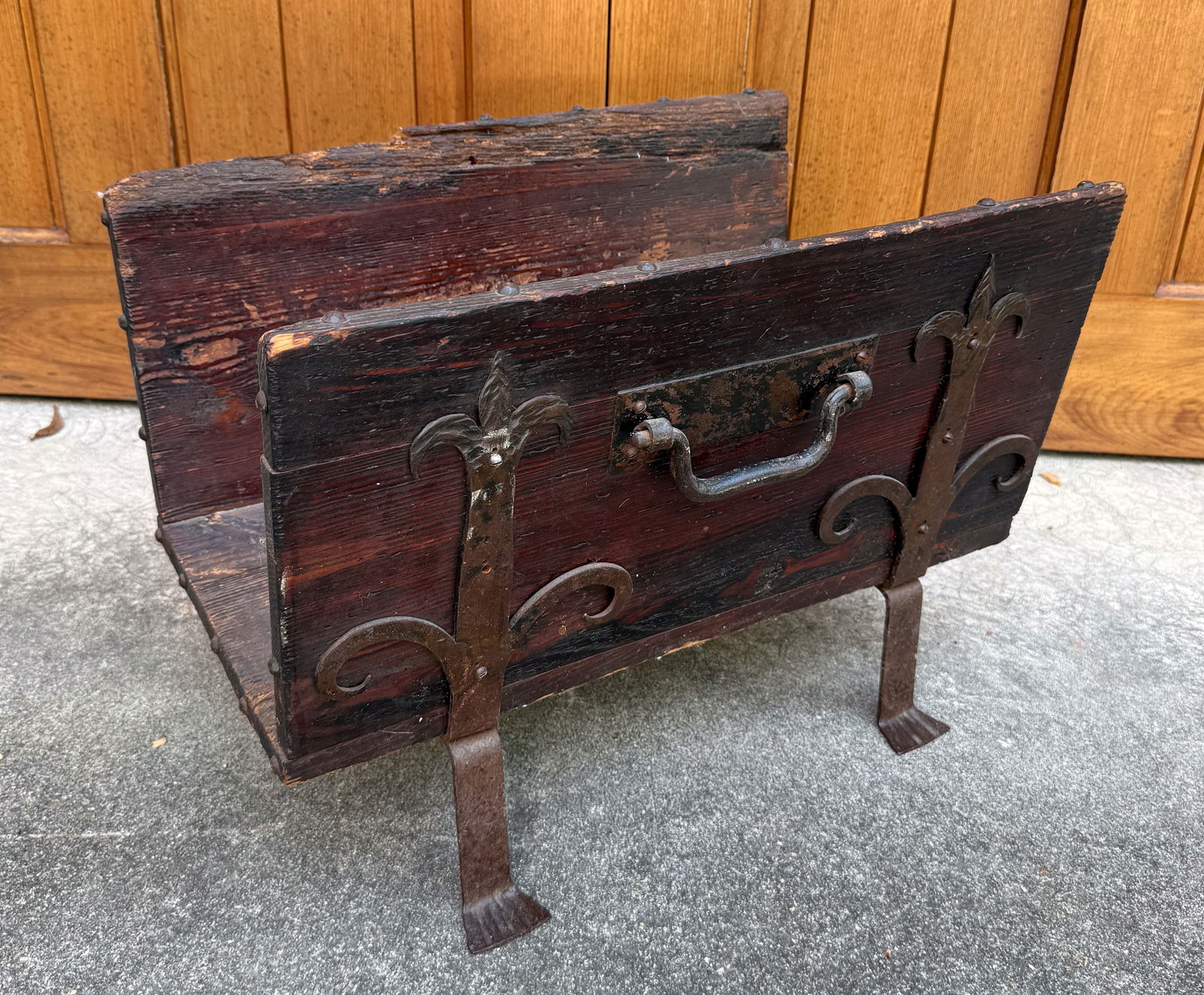 ANTIQUE FIREPLACE WOOD HOLDER: ARTS AND CRAFT STYLE WITH WROUGHT IRON FLORAL MOTIFS. DROP-HANDLE ON EITHER SIDE. BRASS TACKING ON TRIM. 16" X 22" X 14 1/2". PLEASE READ CAREFULLY - THIS IS AN ONLINE ONSITE ONLY AUCTION - Terms for