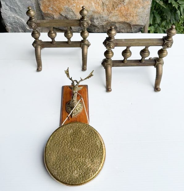 BRASS FIRE DOGS AND GONG: MATCHING PAIR 8" X 7 1/2". HAMMERED BRASS GONG SUSPENDED FROM BRASS BUCK. WOODEN BACKING. GONG IS 6" D. MISSING STRIKER. PLEASE READ CAREFULLY - THIS IS AN ONLINE ONSITE ONLY AUCTION - Terms for Purch