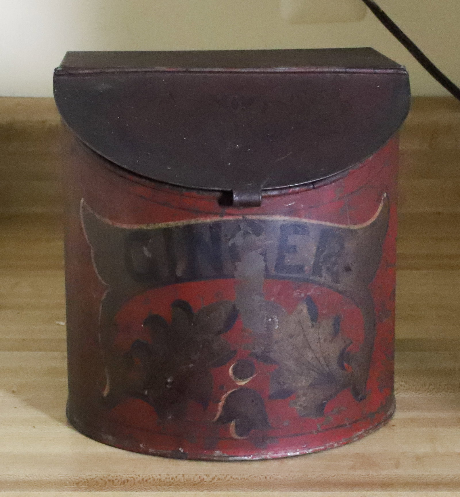 GINGER ADVERTISING TIN: RED / GOLD / BLACK PAINTED SURFACE. HINGED LID. 7" H. PLEASE READ CAREFULLY - THIS IS AN ONLINE ONLY AUCTION - Terms for Purchasing and Shipping of Auction Items. Please read carefully before bidding.