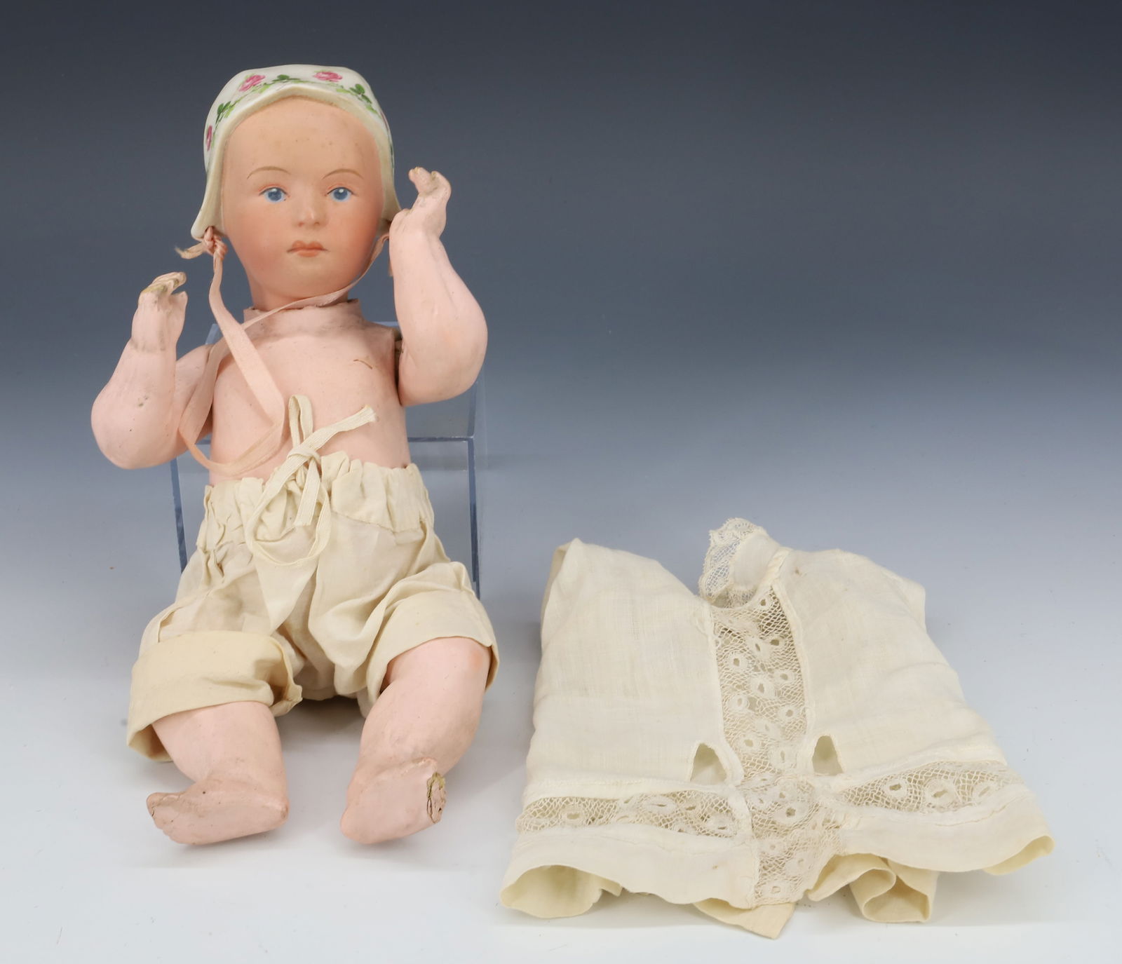 GERMAN BISQUE DOLL: HANDPAINTED BISQUE HEAD AND BONNET. COMPOSITION BODY. MRKD. ON BACK OF NECK. "GERMANY". 9 1/2" L. PLEASE READ CAREFULLY - Terms for Purchasing and Shipping of Auction Items. Please read carefully befo