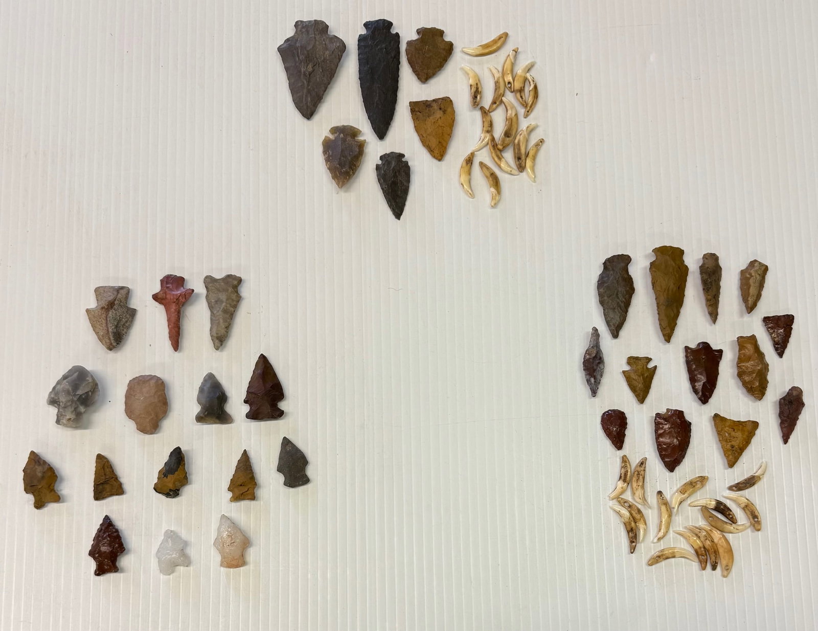 LOT OF (3) CASES OF CARVED STONE ARTIFACTS: VARIOUS SIZE AND SHAPE. LARGEST 3" L. PLUS, GROUP OF TEETH / CLAWS.