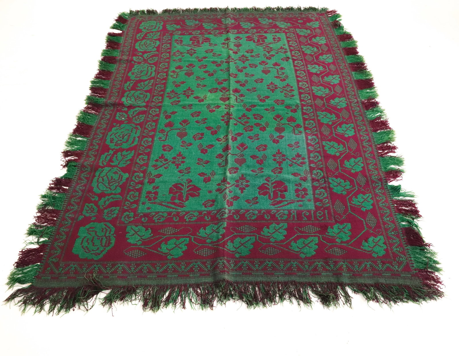 20TH C. GREEN / PURPLE COVERLET, TABLE COVERING: DATED 1912. LEAF / GRAPE CENTER AND LEAF / GRAPE BORDER. FRINGED ON ALL FOUR SIDES. 80" X 54".