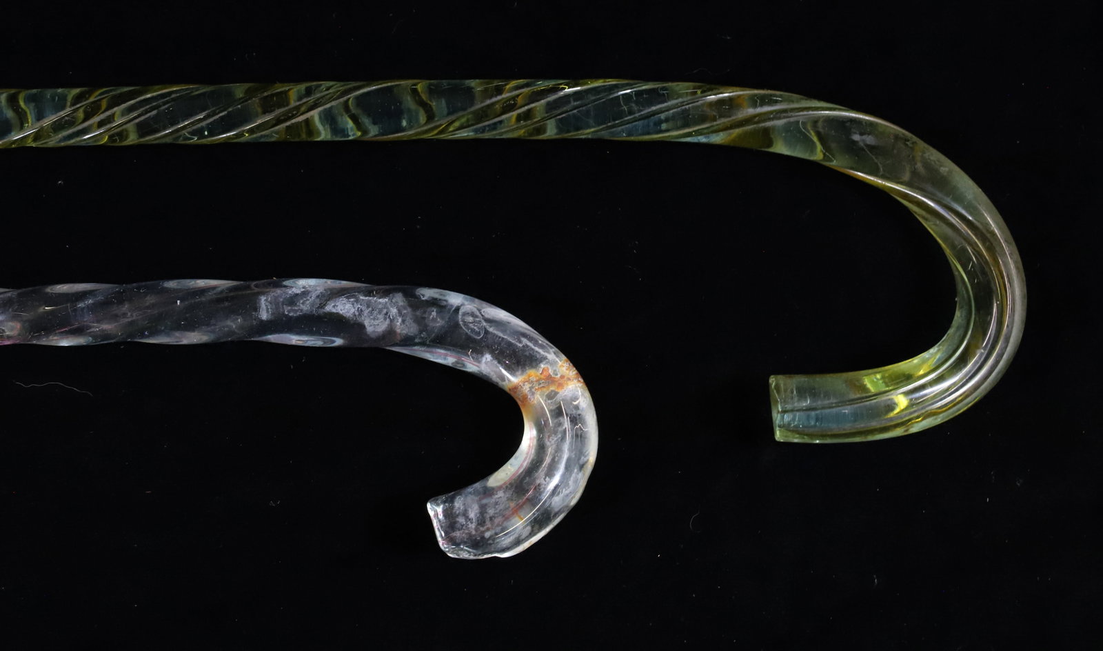 (2) GLASS CANE WHIMSEYS: TWO PARADE CANES. CLEAR WITH PINK THREADING RUNNING THROUGH AND CLEAR/GREEN WITH YELLOW RUNNING THROUGH. 38 1/2" AND 40 1/2".