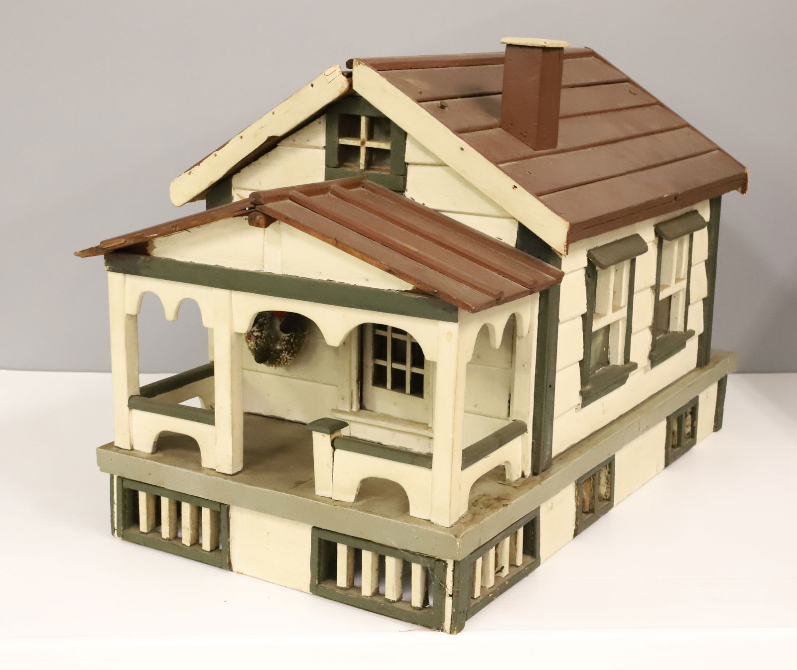 FOLK ART WOODEN HOUSE: RED / WHITE / GREEN BUNGALOW. ROOF LIFTS OFF. VARIOUS FURNISHINGS. 16 1/2" X 25" X 13 1/2".