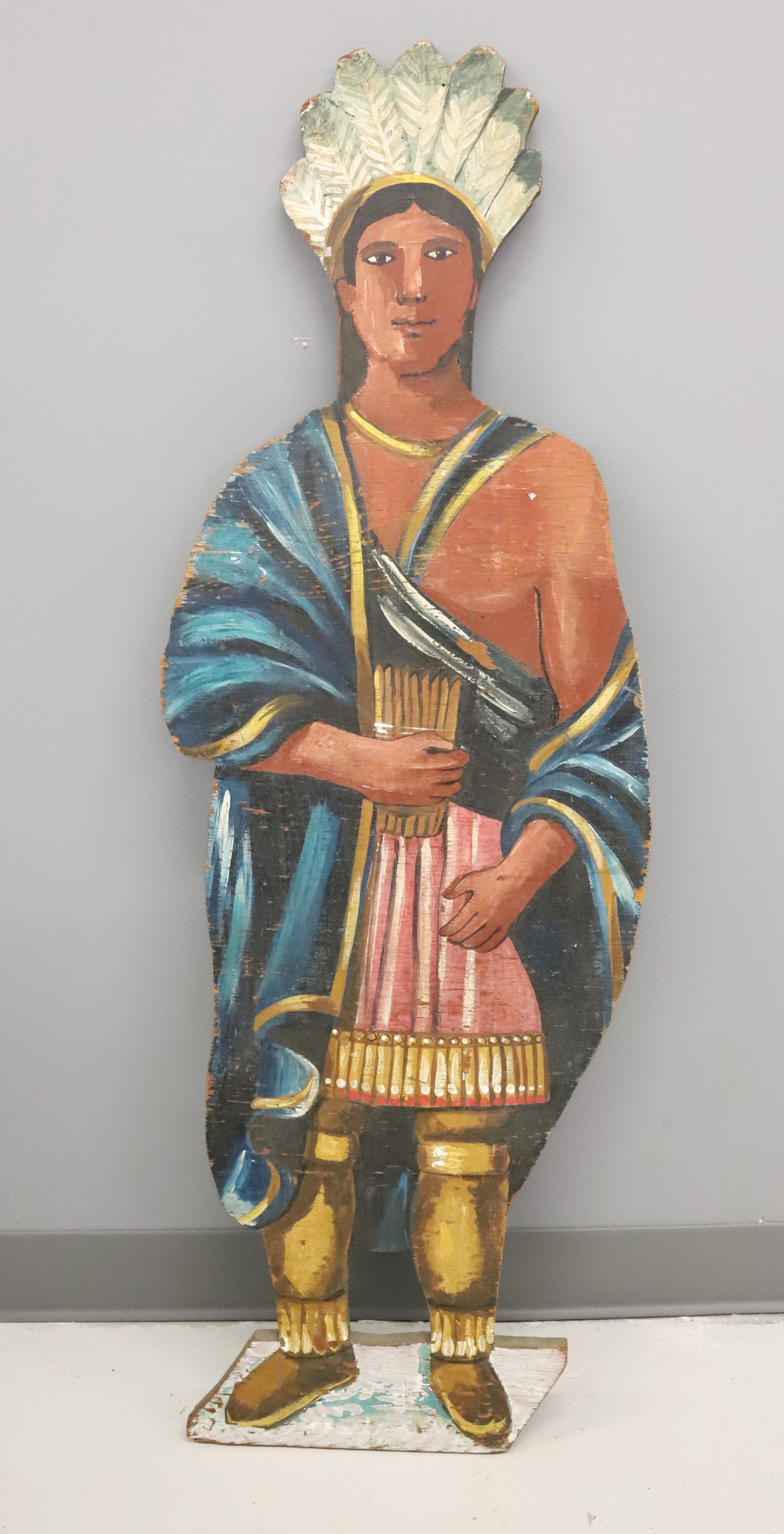 PAINTED NATIVE AMERICAN CUT-OUT: WOODEN WITH DEPICTION OF NATIVE AMERICAN HOLDING TOBACCO. 42" X 15 1/2".