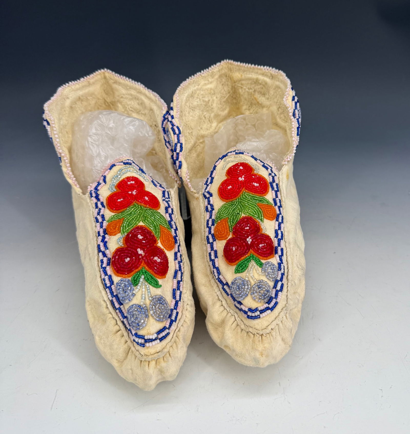 PAIR OF UNUSED BEADED MOCCASINS: VARIOUS COLORED GLASS BEADS SEWN ON HIDE. 11" L.