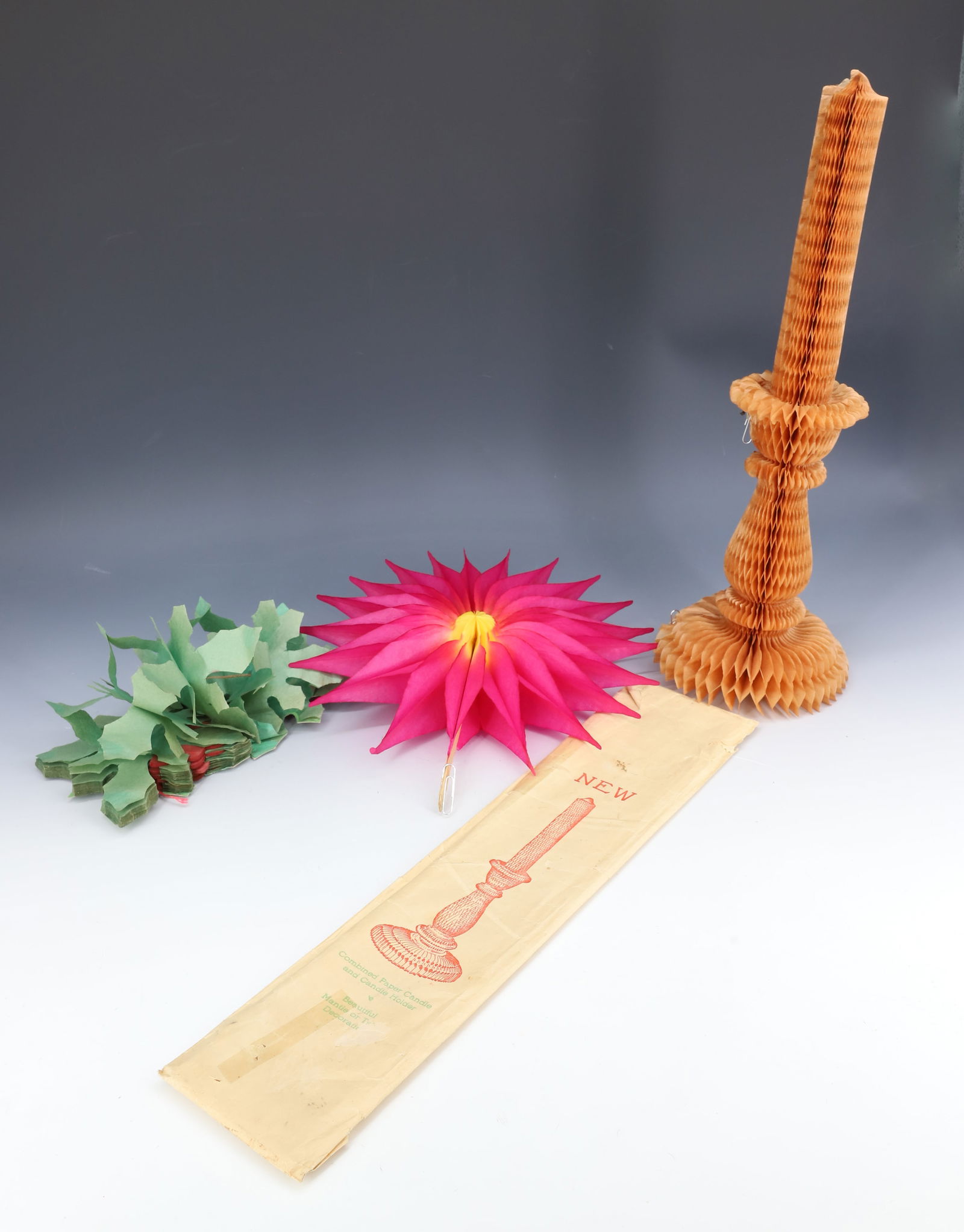 LOT OF HONEYCOMB PAPER CHRISTMAS ITEMS: INCLUDING: POINSETTIA FLOWER, POINSETTIA GARLAND AND PAPER CANDLE/CANDLE HOLDER WITH ORIGINAL SLEEVE 15" H. PLEASE READ CAREFULLY - THIS IS AN ONLINE ONLY AUCTION -Terms for Purchasing and Shipping of