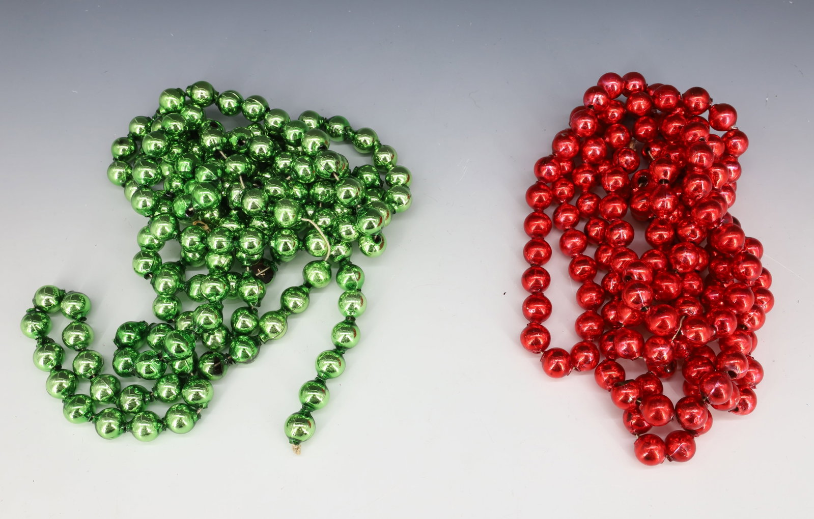 (2) STRANDS OF VINTAGE GLASS CHRISTMAS BEADS, GARLAND: LARGE RED AND GREEN STRAND. PLEASE READ CAREFULLY - THIS IS AN ONLINE ONLY AUCTION -Terms for Purchasing and Shipping of Auction Items. Please read carefully before bidding. Hartzell?s Auction Gallery