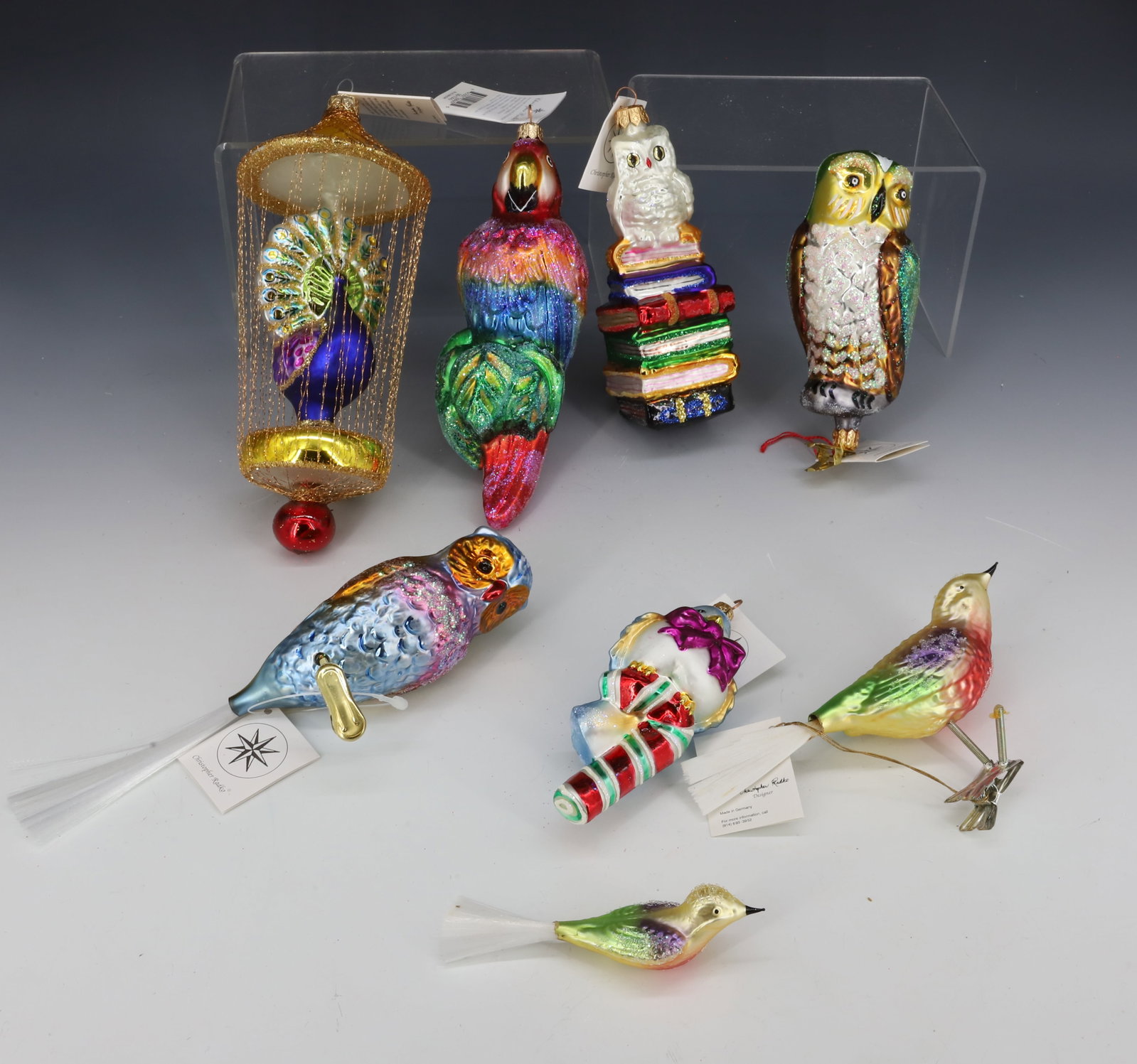 (8) VINTAGE CHRISTOPHER RADKO GLASS BIRD ORNAMENTS: INCLUDING: PEACOCK, PARROT, THREE OWLS, AND MORE. MADE IN POLAND / GERMANY. LARGEST 7" L. ORIGINAL TAGS. PLEASE READ CAREFULLY - THIS IS AN ONLINE ONLY AUCTION -Terms for Purchasing and Shipping of Au