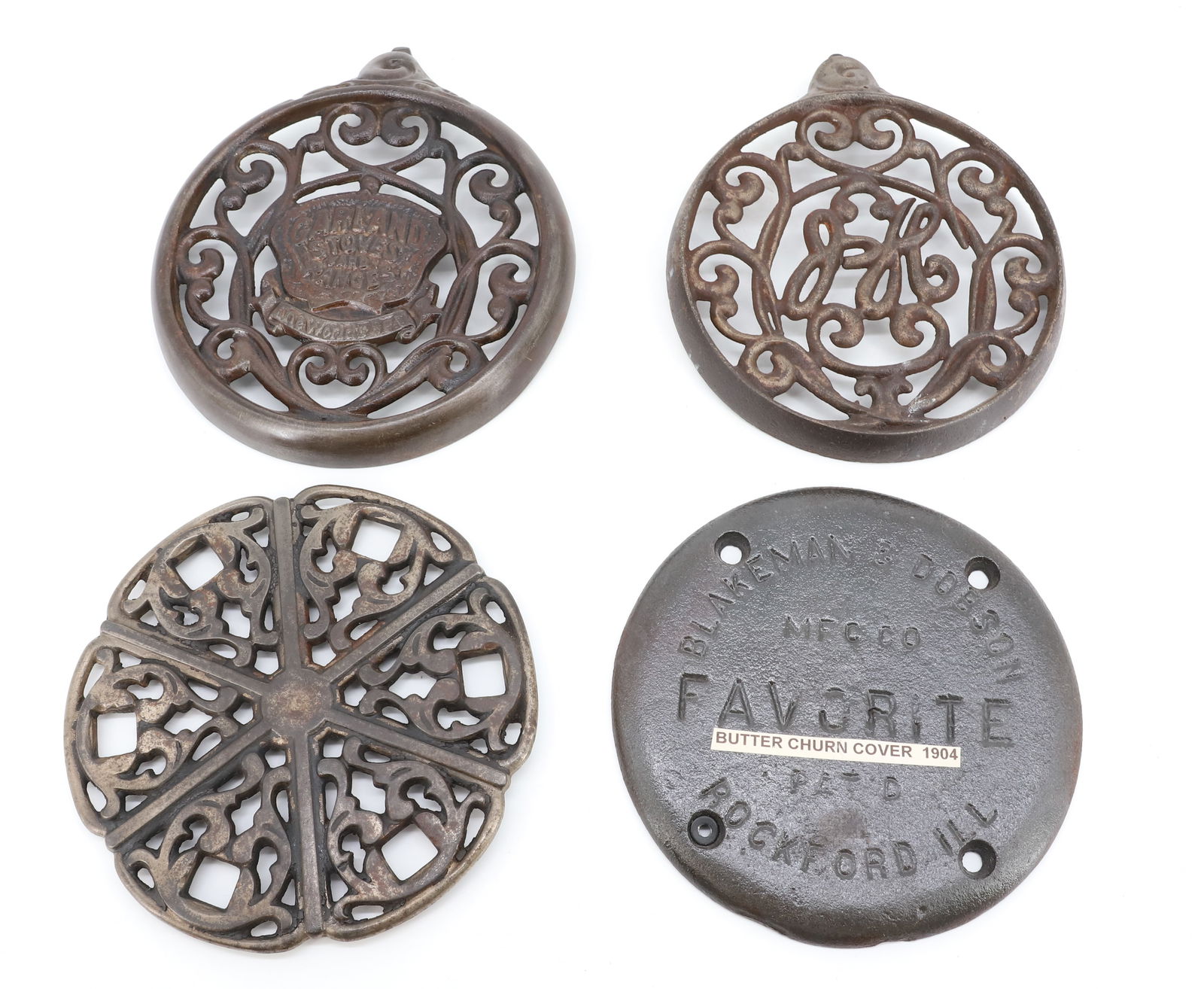LOT OF CAST IRON COVERS: (4) INCLUDING: BUTTER CHURN COVER "BLAKEMAN & DOBSON "FAVORITE" 7 3/8" D. W&P SIMMERING COVER 7 1/2" D. STOVE GRATE MRKD. "GARLAND STOVES AND RANGES, THE WORLD'S BEST" 7 7/8" D. ONE MRKD. "JH". PLEASE