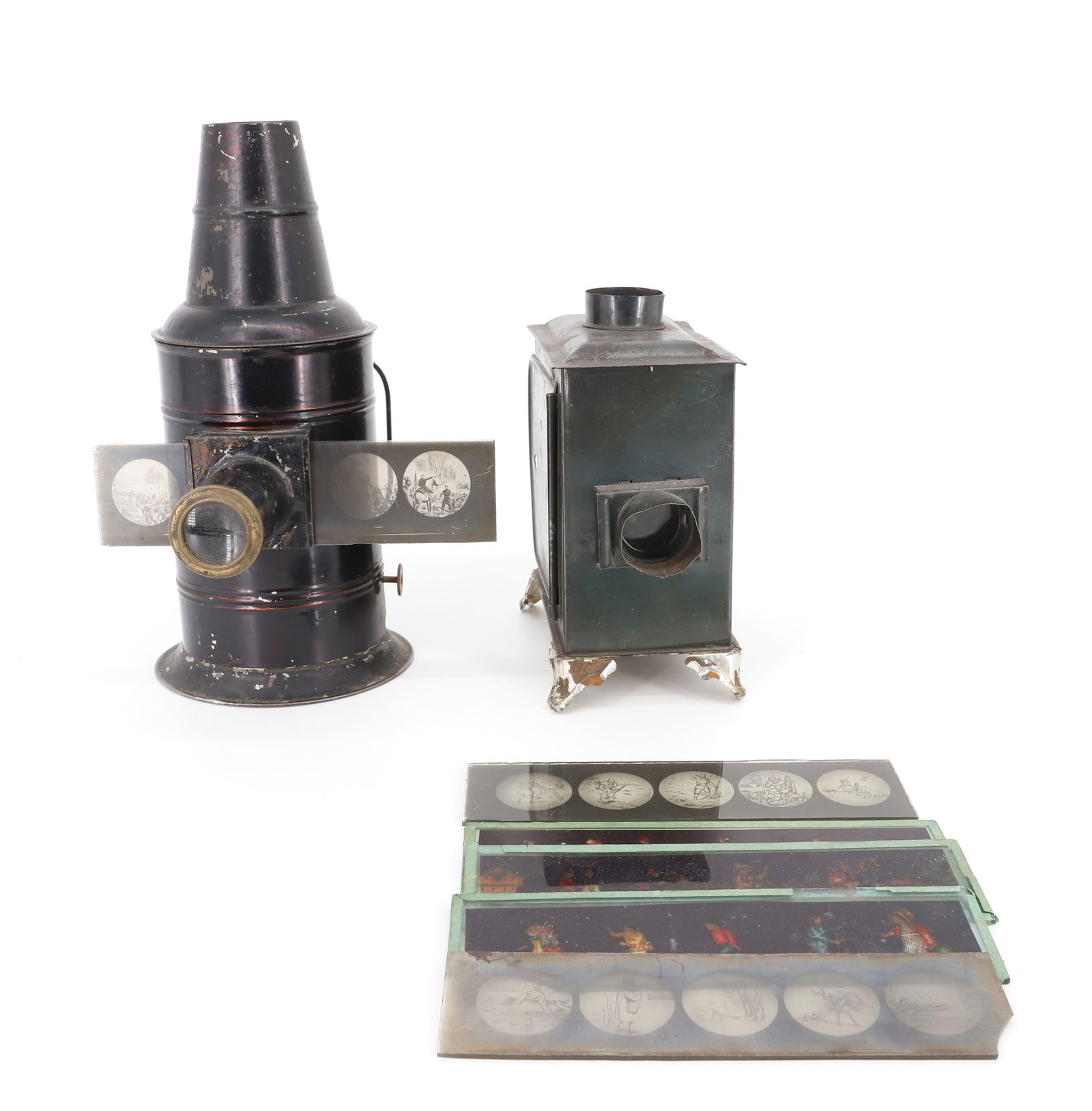 (2) TIN MAGIC LANTERNS: CYLINDRICAL WITH DARK FINISH. 9 3/4" H. GLASS BLACK/WHITE AND COLOR CHILDREN'S SLIDES. PLEASE READ CAREFULLY - Terms for Purchasing and Shipping of Auction Items. Please read carefully before bidding.