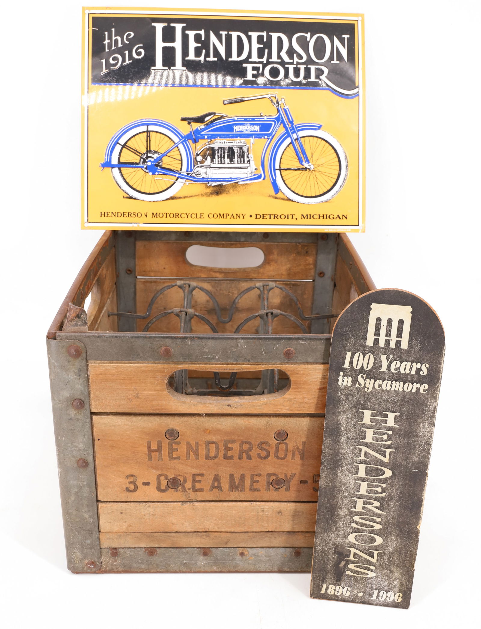 HENDERSON CRATE AND MOTORCYCLE SIGN: "HENDERSON CREAMERY" WOOD/METAL CRATE. 15" L. CONTEMPORARY EMBOSSED ADVERTISING SIGN BY AAA SIGN COMPANY. COMPANY INFORMATION ON BACK. 11" X 14". WITH, HENDERSONS "100 YEARS IN SYCAMORE" MEMENTO. PLEA