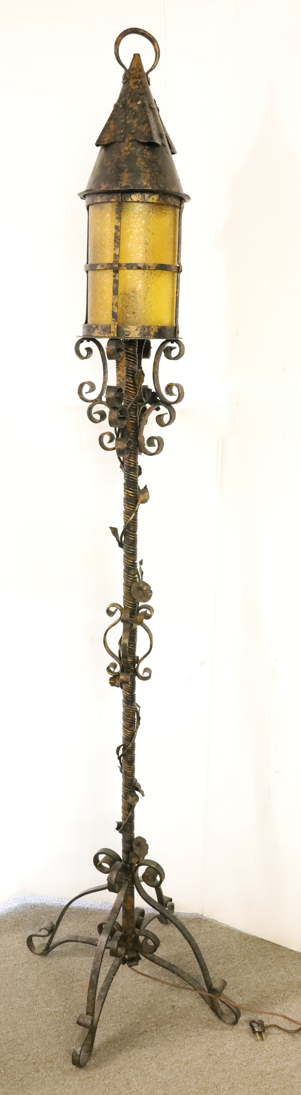 ARTS & CRAFT FLOOR LAMP: WROUGHT IRON WITH YELLOW/AMBER GLASS INSERT. BASE HAS VINE/FLORAL WRAPPED AROUND SHAFT. BLACK SURFACE WITH GILT. 73 1/4" H. PLEASE READ CAREFULLY - Terms for Purchasing and Shipping of Auction Items.