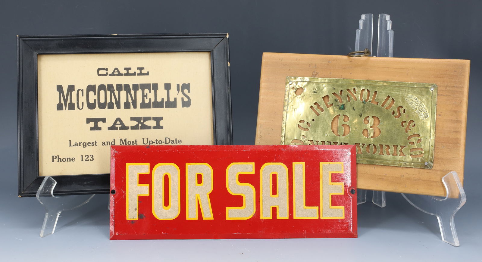 VINTAGE SIGNS AND BRASS STENCIL: TIN "FOR SALE" SIGN 9 1/4" L., FRAMED CARDBOARD "CALL MCCONNELL'S TAXI" 6 1/4" X 8 1/4" AND BRASS "D.C. REYNOLDS & CO. 63 NEW YORK" STENCIL MOUNTED ON WOOD. PLEASE READ CAREFULLY - Terms for Purchasin