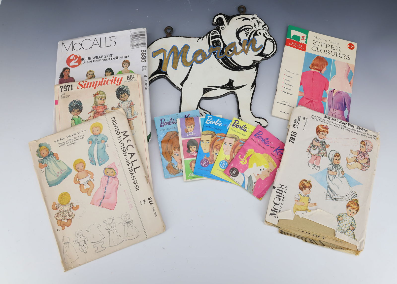 MACK TRUCK, BARBIE, MCCALLS LOT: PAINTED METAL "MACK" BULLDOG HOUSE SIGN 10" L., BARBIE AND KEN 1960S FASHION BOOKLETS AND VINTAGE MCCALL'S PATTERNS PLEASE READ CAREFULLY - Terms for Purchasing and Shipping of Auction Items. Please r
