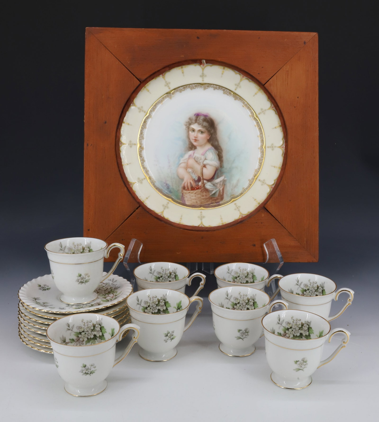 GERMAN DEMITASSE SET AND LIMOGES PAINTED PLATE: SET OF EIGHT CUPS/SAUCERS MRKD. FRANCONIA, HAWTHORN, GERMANY. SAUCERS 4 7/8" D. WITH, LIMOGE PLATE DEPICTING YOUNG GIRL WITH BASKET AND BOOK. FRAMED IN WOODEN SQUARE TO HANG. MRKD. ON BACK. PLATE IS 8
