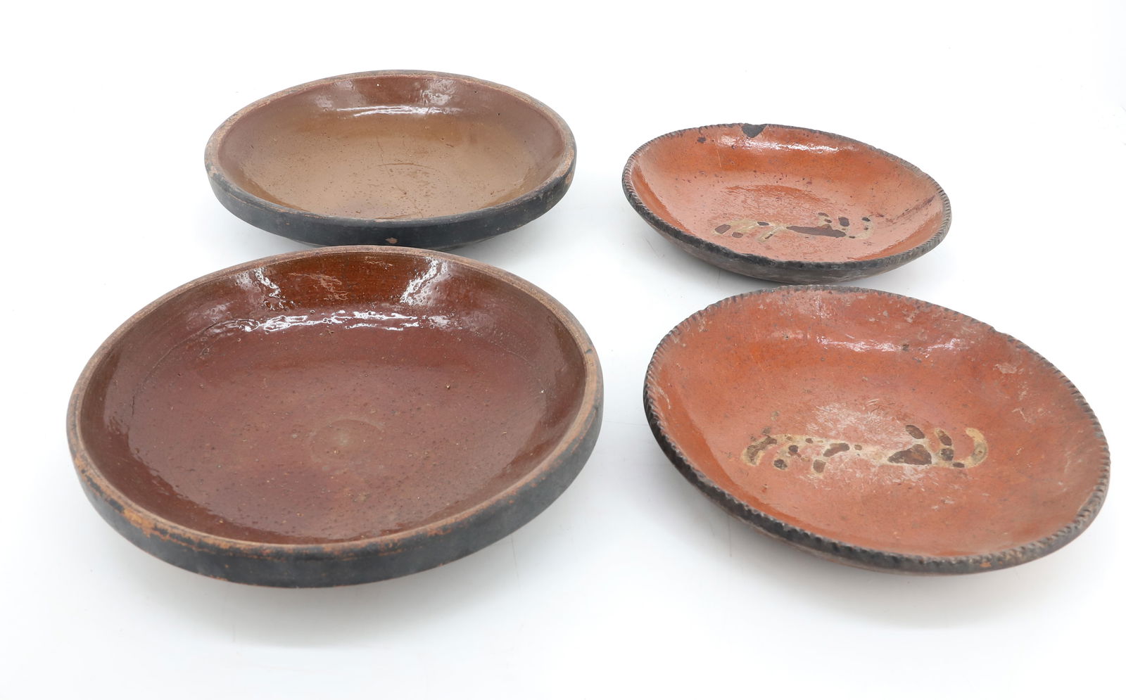 LOT OF REDWARE PIE PLATES: TWO MATCHING SLIP DECORATED PLATES 7 1/2" D. WITH, TWO MOLDED PLATES IN BROWN GLAZE. PLEASE READ CAREFULLY - Terms for Purchasing and Shipping of Auction Items. Please read carefully before bidding. H