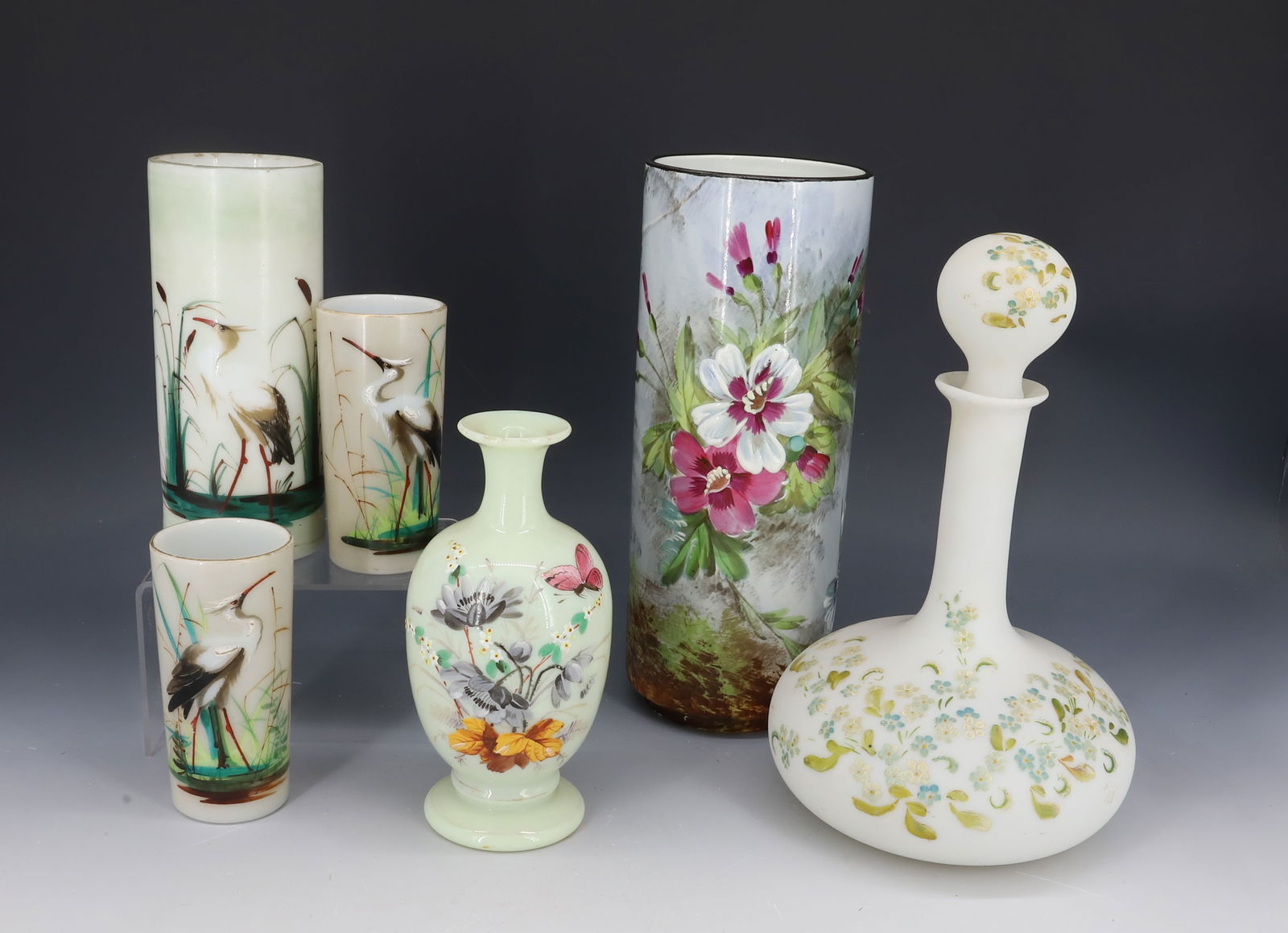 LOT OF DECORATED MILK GLASS AND PORCELAIN: INCLUDING: THREE HERON PAINTED VASES 4 1/4" TO 6 1/2" H., FLORAL PAINTED DRESSER BOTTLE W/STOPPER, PORCELAIN FLORAL VASE W/ BUTTERFLY MRKD. "B & CIE" 9 3/4" H. WITH, SMALLER CUSTARD GLASS VASE WITH FL