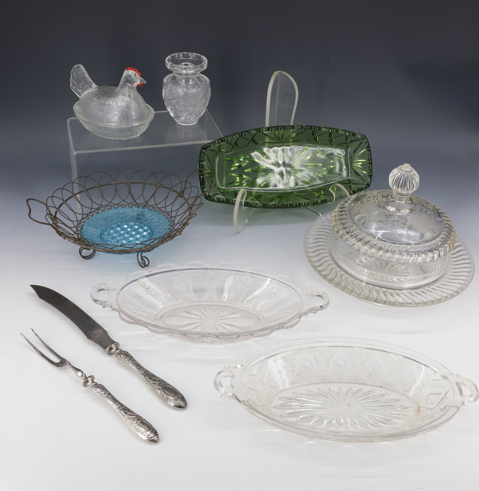 VARIETY LOT OF PRESSED GLASS: INCLUDING: TWO CLEAR CELERY DISHES. WIRE BASKET WITH LIGHT BLUE PLATE INSERT 9" D., HEN ON NEST, COVERED BUTTER DISH AND MORE. PLEASE READ CAREFULLY - Terms for Purchasing and Shipping of Auction Item