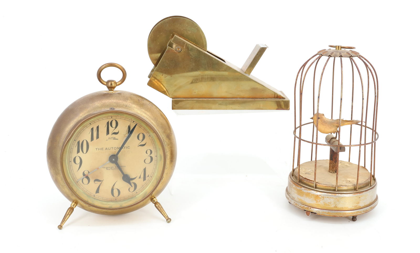 LOT OF BRASS ITEMS: MCM TAPE DISPENSER 7 1/4" L., NEW HAVEN ALARM CLOCK PAT. 1908 (6" X 5 3/4") RUNS. MUSICAL BIRD CAGE (JAPAN) 7 3/4" H. PLAYS BUT BIRD DOES NOT FUNCTION PROPERLY. PLEASE READ CAREFULLY - Terms for Purch