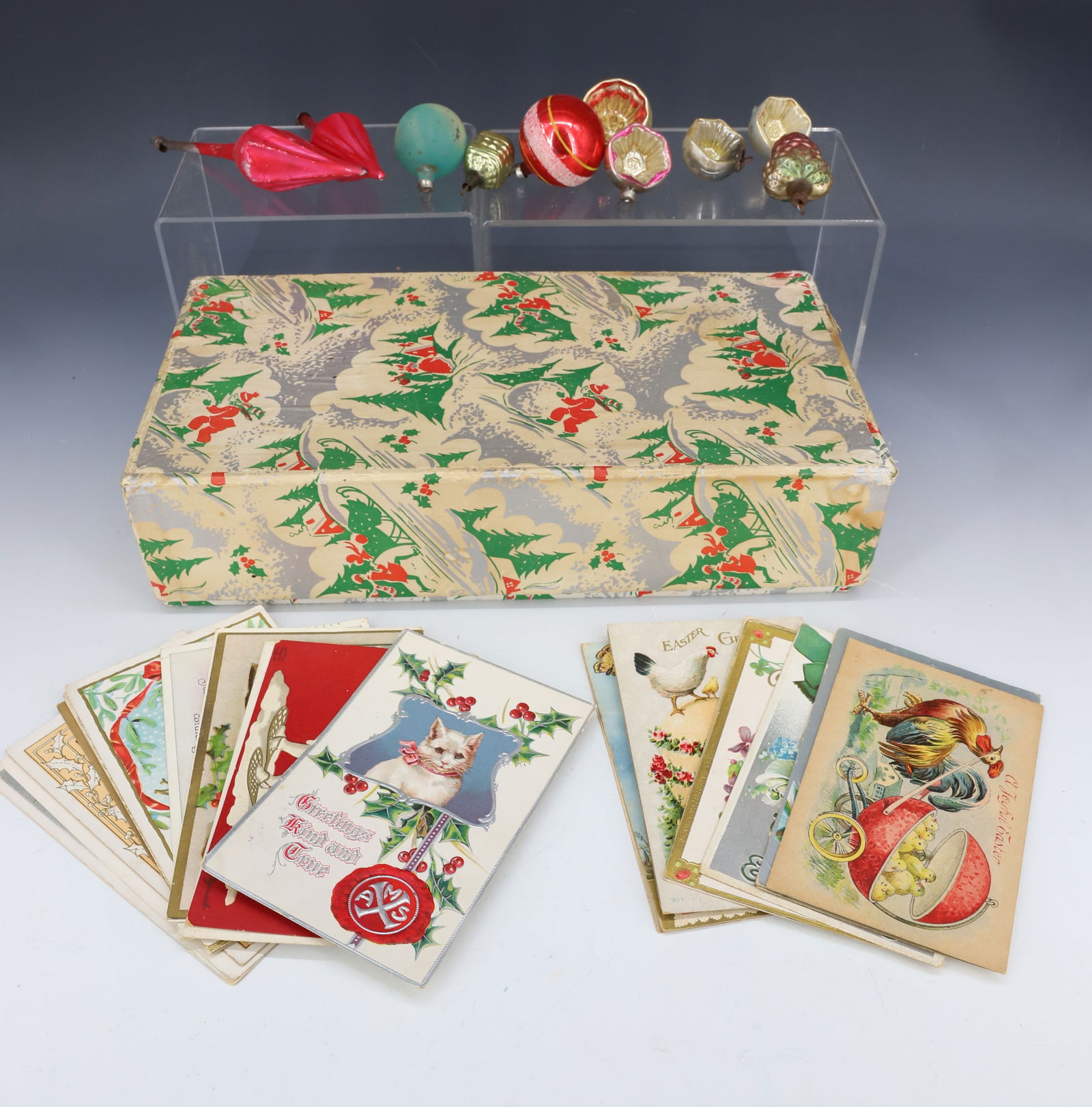LOT OF CHRISTMAS POSTCARDS AND ORNAMENTS: VARIETY OF CHRISTMAS AND EASTER POSTCARDS, BLOWN GLASS ORNAMENTS (LARGEST 6" L.) AND LIDDED XMAS GIFT BOX 12 1/2" L. PLEASE READ CAREFULLY - Terms for Purchasing and Shipping of Auction Items. Please