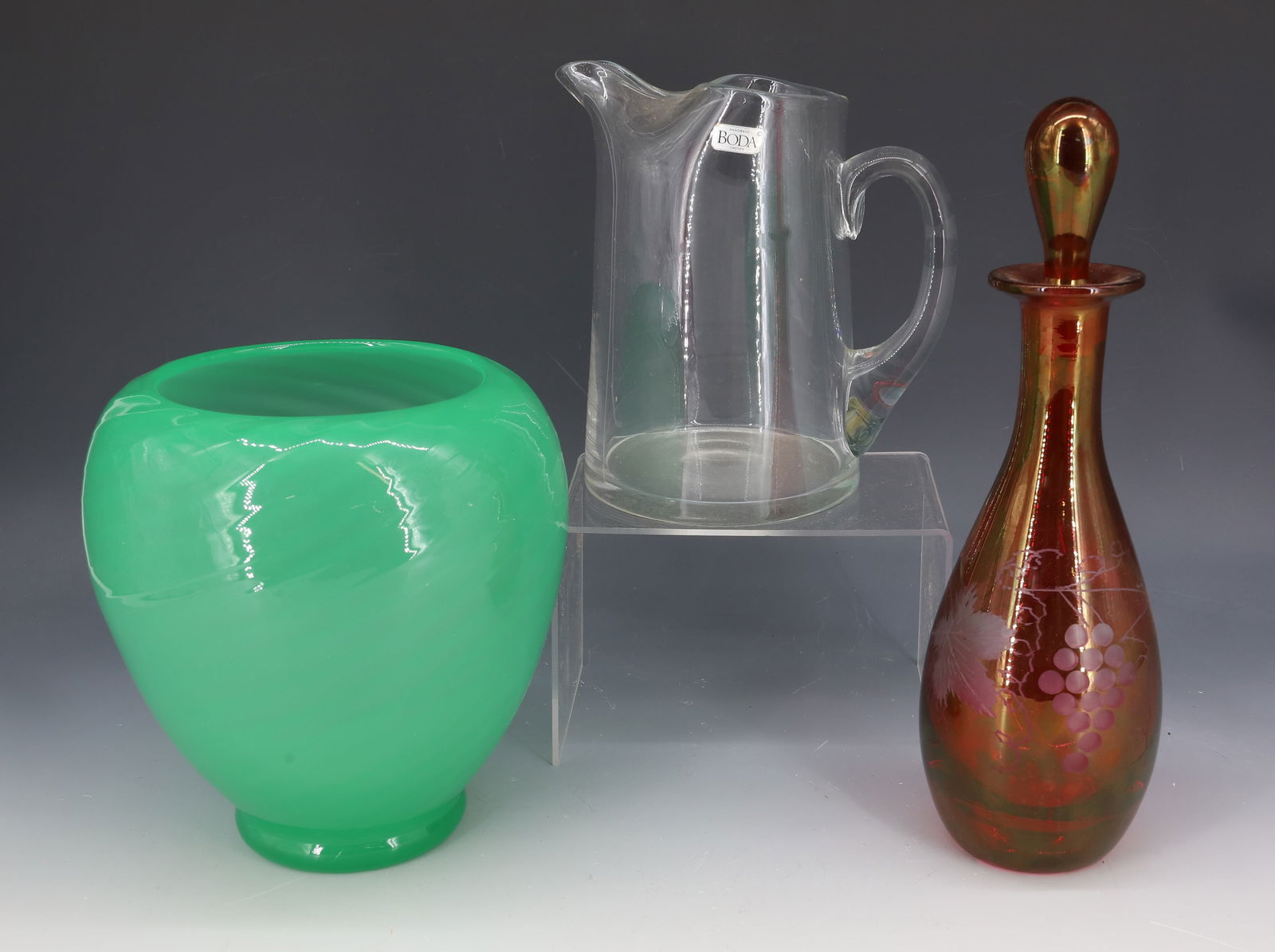 BLOWN GLASS PITCHER, VASE AND DECANTER: PITCHER HAS "BODA, SWEDEN" LABEL. APPLIED HANDLE. 6 3/4" H. GREEN SWIRLED BASE WITH SMOOTH PONTIL 6 3/4" H. CRANBERRY DECANTER WITH STOPPER, ETCHED GRAPE PATTERN. PLEASE READ CAREFULLY - Terms for Pur