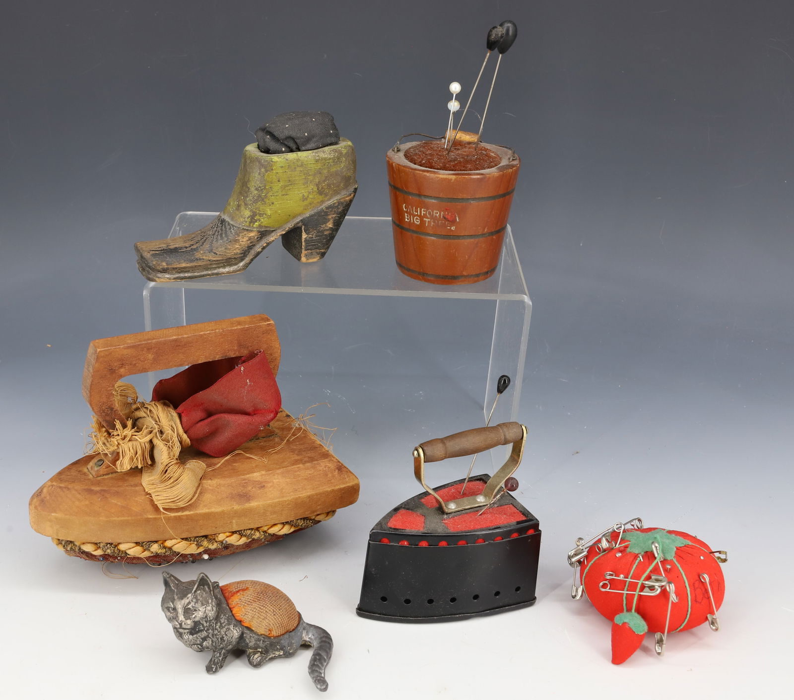LOT OF ANTIQUE PIN CUSHIONS: LARGE WOODEN IRON 5 1/2". METAL IRON PINCUSHION/TAPE MEASURE. "CALIFORNIA BIG TREE" BUCKET PINCUSHION. WHITE METAL CAT WITH PINCUSHION / PEN DIP/WIPE BACK, CARVED PAINTED SHOE AND MORE. PLEASE READ CA