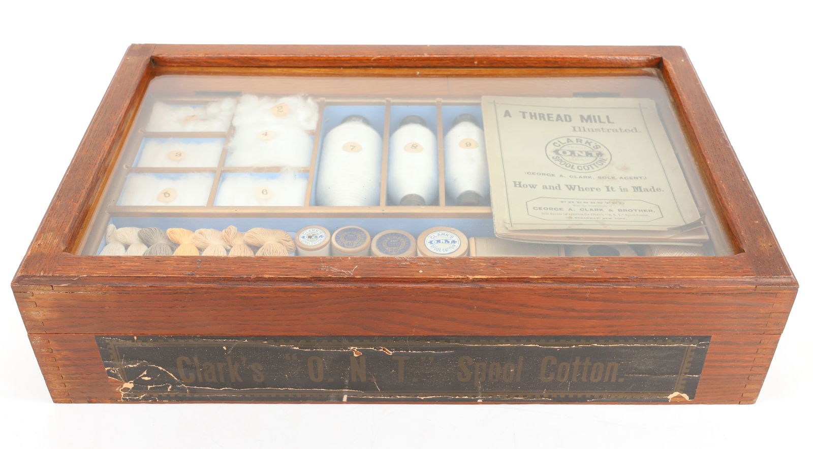 CLARK'S SPOOL COTTON TEACHING DISPLAY: OAK BOX WITH HINGED GLASS LID. DIVIDED INTERIOR WITH SAMPLES OF COTTON, THREAD AND MORE. INCLUDING: " A THREAD MILL ILLUSTRATED" BOOKLET. 4 1/4" X 17 3/4" X 11". PLEASE READ CAREFULLY - Terms for Purc