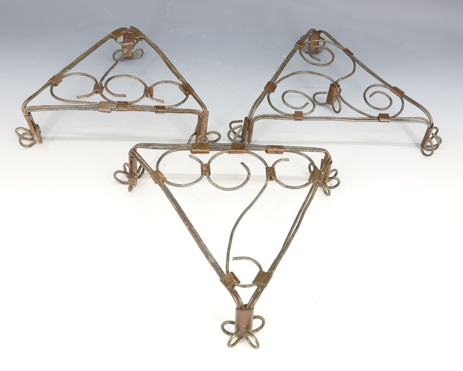 (3) ANTIQUE TRIANGULAR WIRE TRIVETS: BENT WIRE AND METAL TRIVETS. LARGEST 9 1/4" X 9 1/4". PLEASE READ CAREFULLY - Terms for Purchasing and Shipping of Auction Items. Please read carefully before bidding. Hartzell’s Auction Gallery