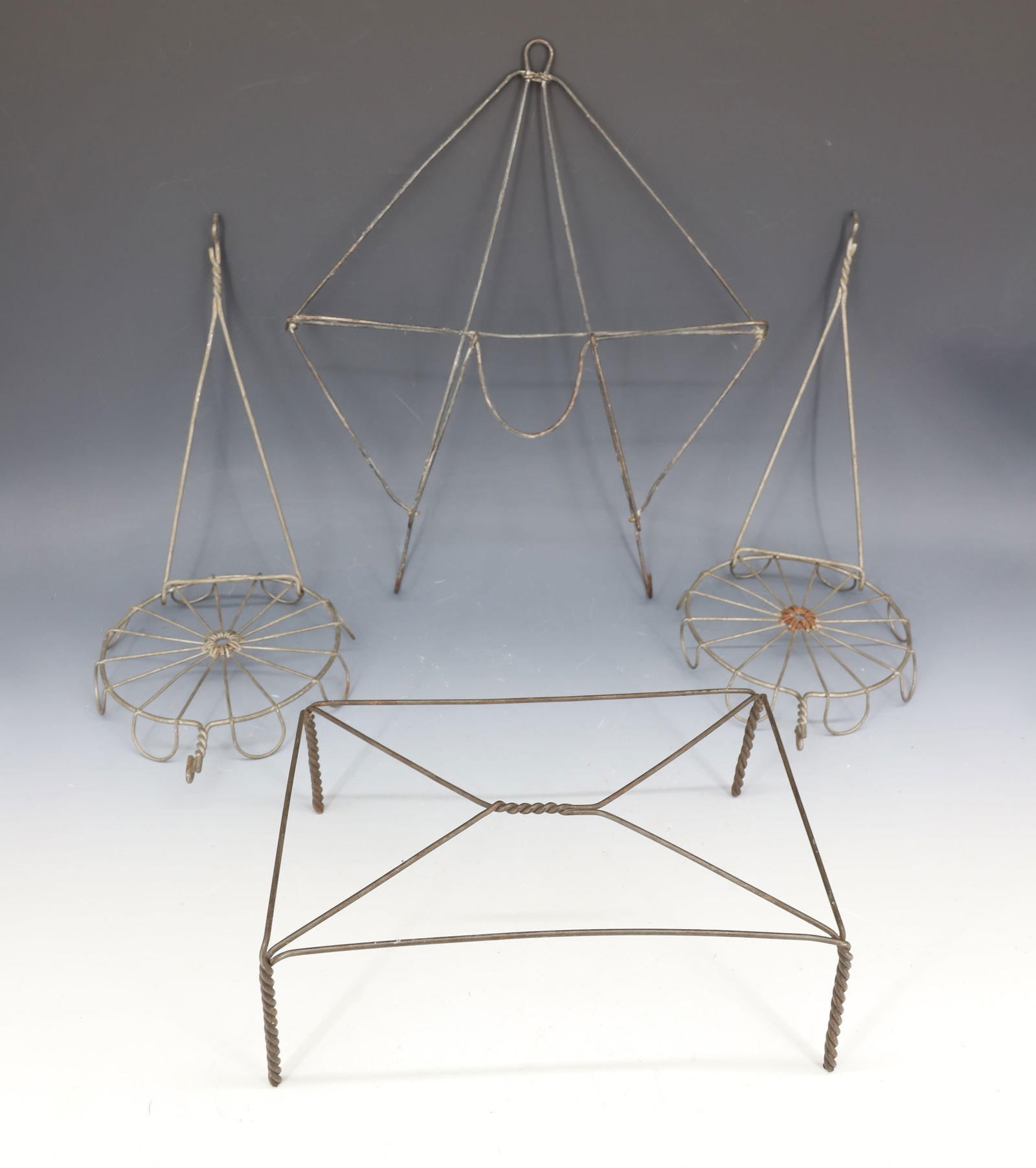 LOT OF VINTAGE WIRE ITEMS: WALL RACK WITH BOTTOM HOOKS 14" X 12". (2) PLANT HOLDERS AND RECTANGULAR TRIVET. 3" X 9" X 6". PLEASE READ CAREFULLY - Terms for Purchasing and Shipping of Auction Items. Please read carefully before
