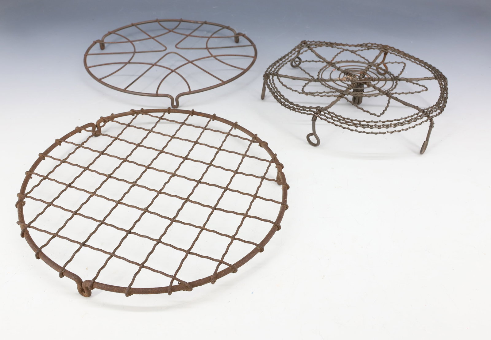 (3) ANTIQUE WIRE TRIVETS: VARIOUS SIZES AND FORMS. LARGEST 8" D. PLEASE READ CAREFULLY - Terms for Purchasing and Shipping of Auction Items. Please read carefully before bidding. Hartzell’s Auction Gallery. Hartzell's Au