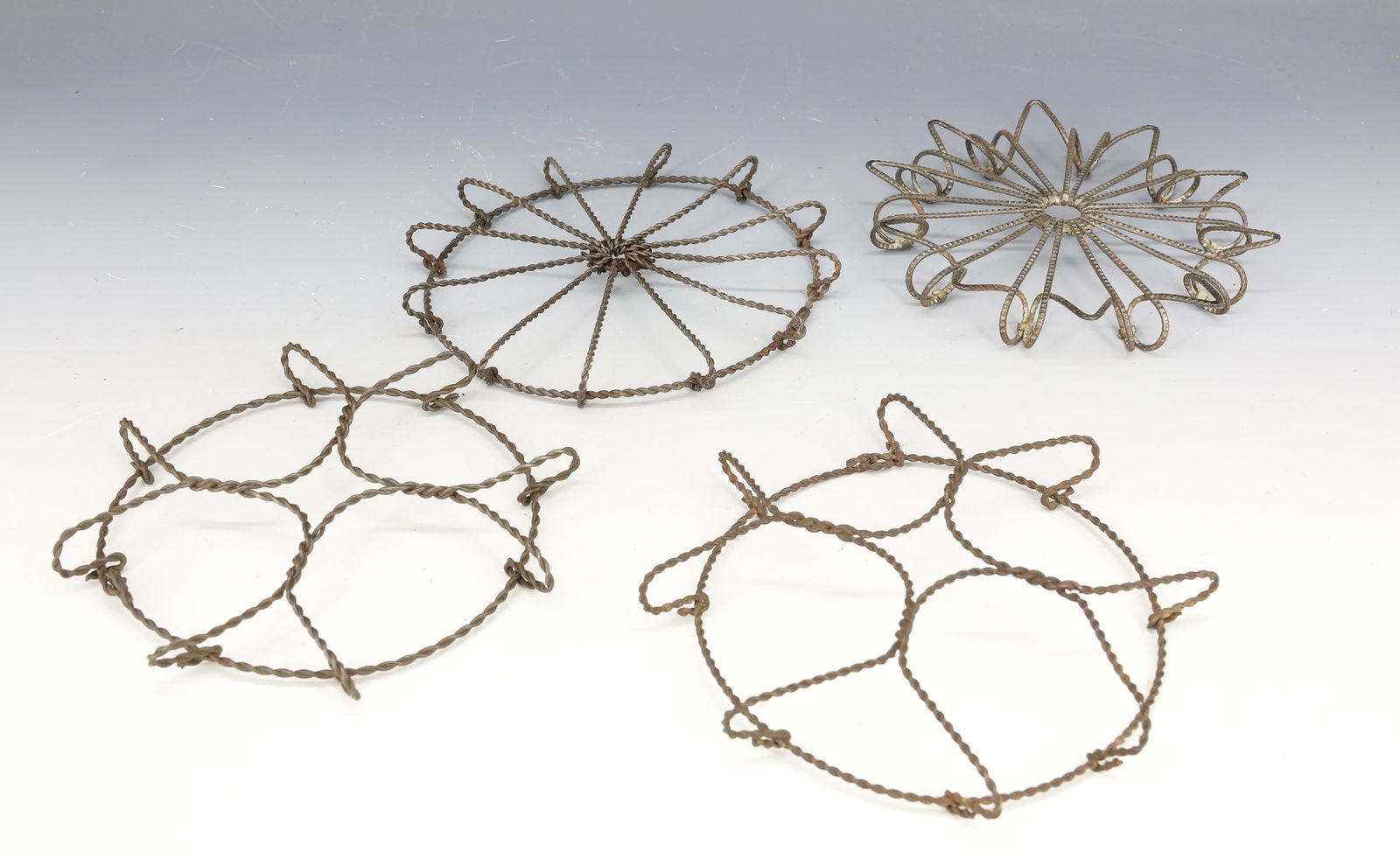 (4) ANTIQUE WIRE TRIVETS: LARGEST 6 1/4" D. PLEASE READ CAREFULLY - Terms for Purchasing and Shipping of Auction Items. Please read carefully before bidding. Hartzell’s Auction Gallery. Hartzell's Auction Gallery will ha