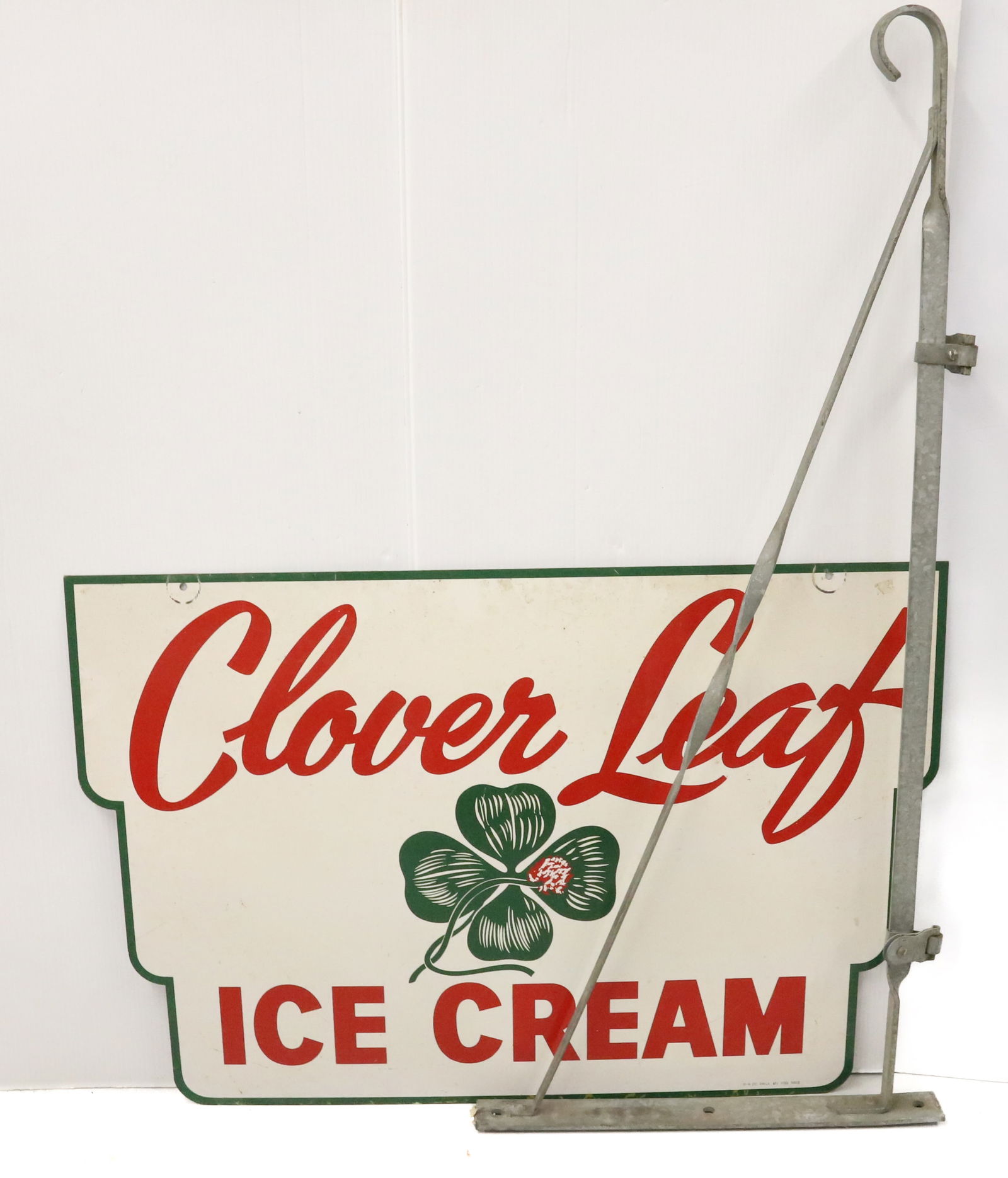 CLOVER LEAF ICE CREAM PORCELAIN SIGN: DOUBLE-SIDED IN RED / WHITE / GREEN. MRKD. M-H CO. PHILA, FL 1159 5612. WITH HANGING BRACKET. SIGN IS 24" X 35 3/4". BRACKET 45" L. PLEASE READ CAREFULLY - Terms for Purchasing and Shipping of Auction
