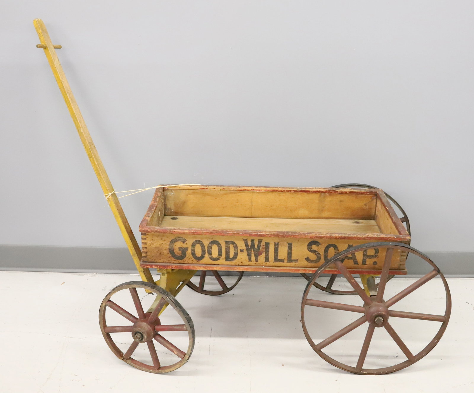 ANTIQUE "GOOD WILL SOAP" ADVERTISING WAGON: DOVETAILED BODY WITH YELLOW / RED / BLACK PAINT. STENCILED ADVERTISEMENT ON ALL FOUR SIDES. BODY IS 15" X 26 1/2" X 14". WHEELS ARE METAL TRIMMED. PLEASE READ CAREFULLY - Terms for Purchasing and Ship