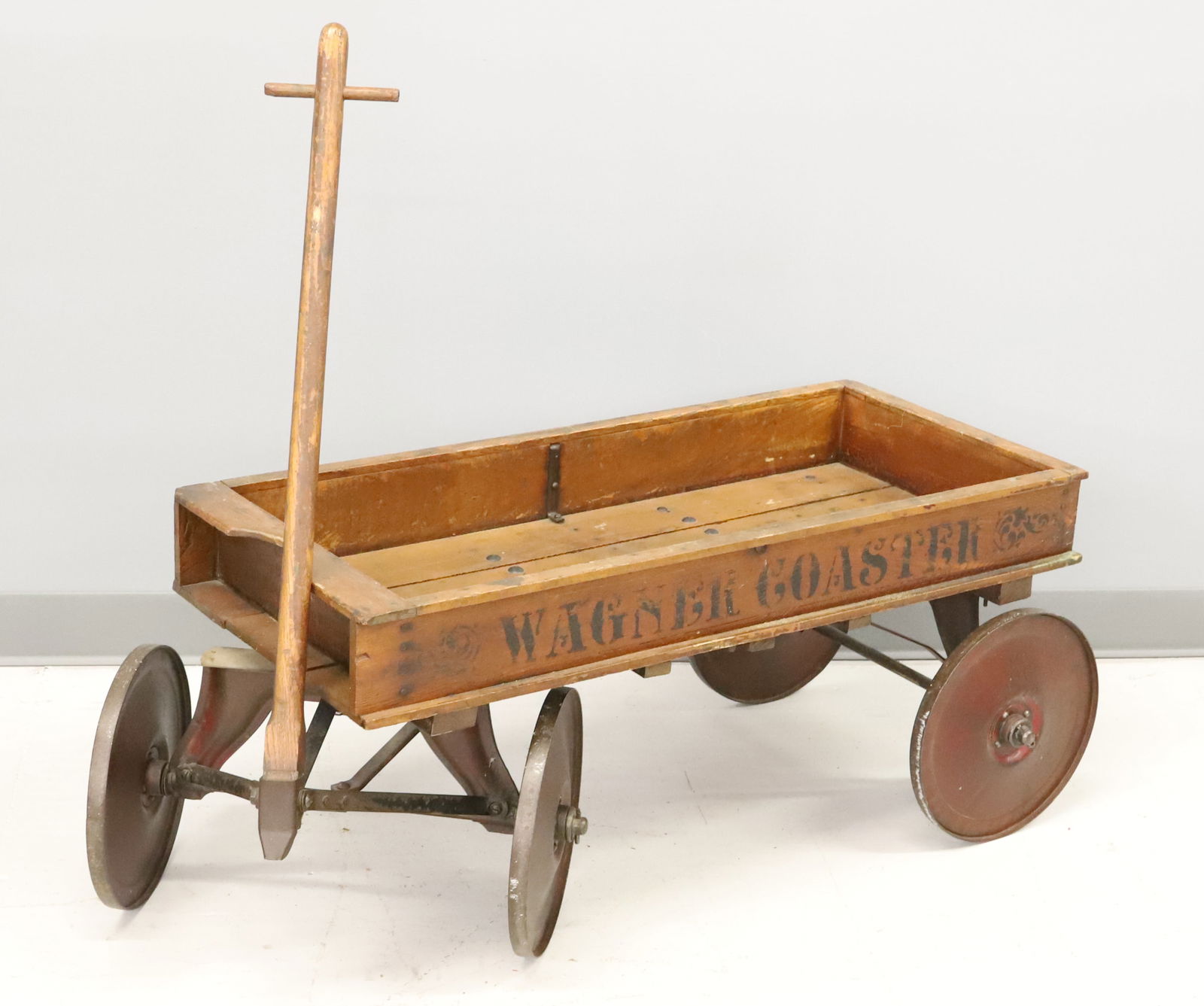 WAGNER COASTER WAGON: CHILD'S WOODEN WAGON WITH PAINTED METAL WHEELS. 16 1/2" X 36" X 15 3/4". PLEASE READ CAREFULLY - Terms for Purchasing and Shipping of Auction Items. Please read carefully before bidding. Hartzell̵
