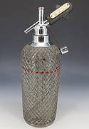 METAL WRAPPED SELTZER BOTTLE: GLASS WITH WOVEN WIRE COVERING. MRKD. MADE IN CZECHOSLOVAKIA ON BOTTOM. TOPPER MRKD. NEW YORK. 13 1/4" H. PLEASE READ CAREFULLY - SINCE THIS IS A COIN SALE PLEASE NOTE. ITEMS MUST BE PAID FOR