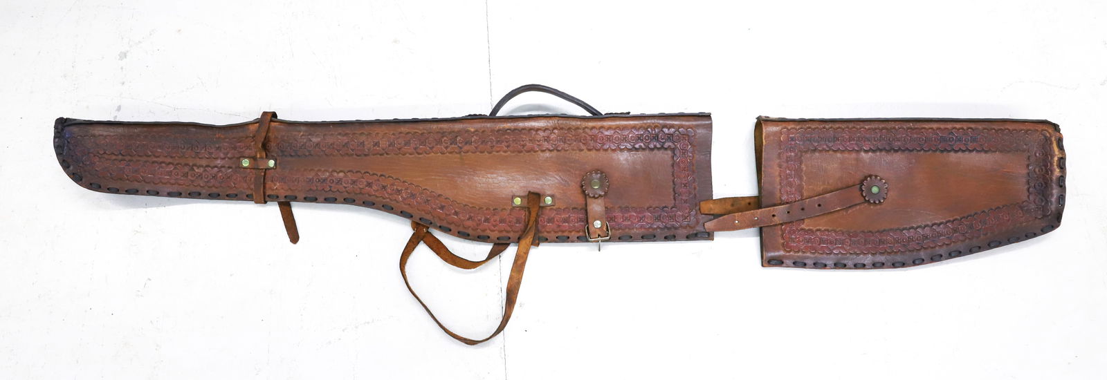 TOOLED LEATHER RIFLE CASE: OVERALL DECORATION WITH LEATHER LACED SIDE. 51" L. PLEASE READ CAREFULLY - SINCE THIS IS A COIN SALE PLEASE NOTE. ITEMS MUST BE PAID FOR THROUGH LIVE AUCTIONEERS OR WITH CASH OR CHECK IN PERSON - Term