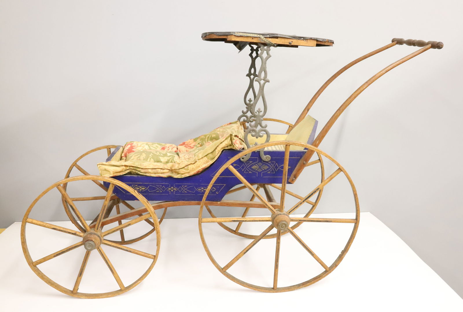 ANTIQUE DOLL CARRAIGE: WOOD BODY WITH ROYAL BLUE PAINT AND GOLD STENCIL, WOOD SPOKE WHEELS,PATENT LEATHER TOP WITH METAL BRACES 24" X 36" PLEASE READ CAREFULLY - Terms for Purchasing and Shipping of Auction Items.