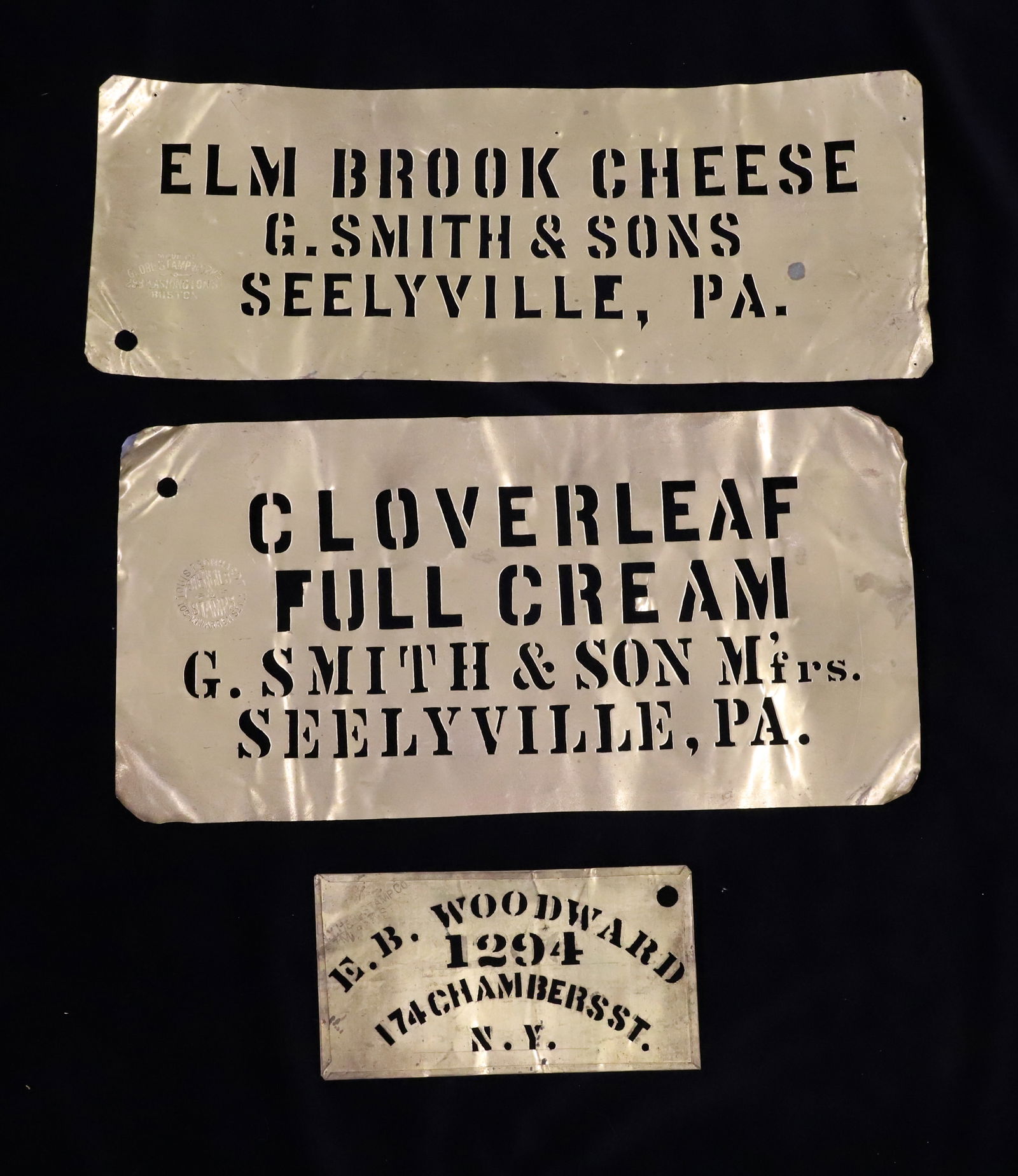 LOT OF (3) ANTIQUE BRASS STENCILS: CLOVERLEAF FULL CREAM, G. SMITH & SON M'FRS. SEELYVILLE, PA (LOUIS LEONHARDT STENCILS) 6 1/2" X 12 7/8". SMALL "E.B. WOODWARD 1294, 174 CHAMBER ST. N.Y. ( 3 1/8" X 5 7/8"). WITH, "ELM BROOK CHEESE, G.