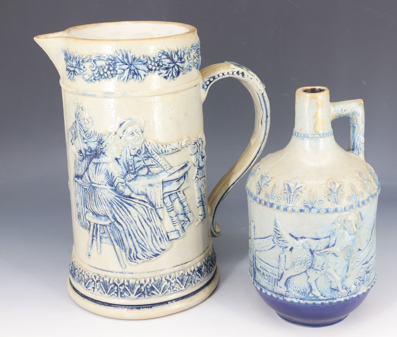STONEWARE PITCHER AND JUG, WHITE'S UTICA: BLUE MOLDED STONEWARE TAVERN SCENE PITCHER 9 3/8" H. (MRKD. 5 ON BOTTOM). WITH, RABBIT HUNT JUG 7 3/4" H. PLEASE READ CAREFULLY - SINCE THIS IS A COIN SALE PLEASE NOTE. ITEMS MUST BE PAID FOR