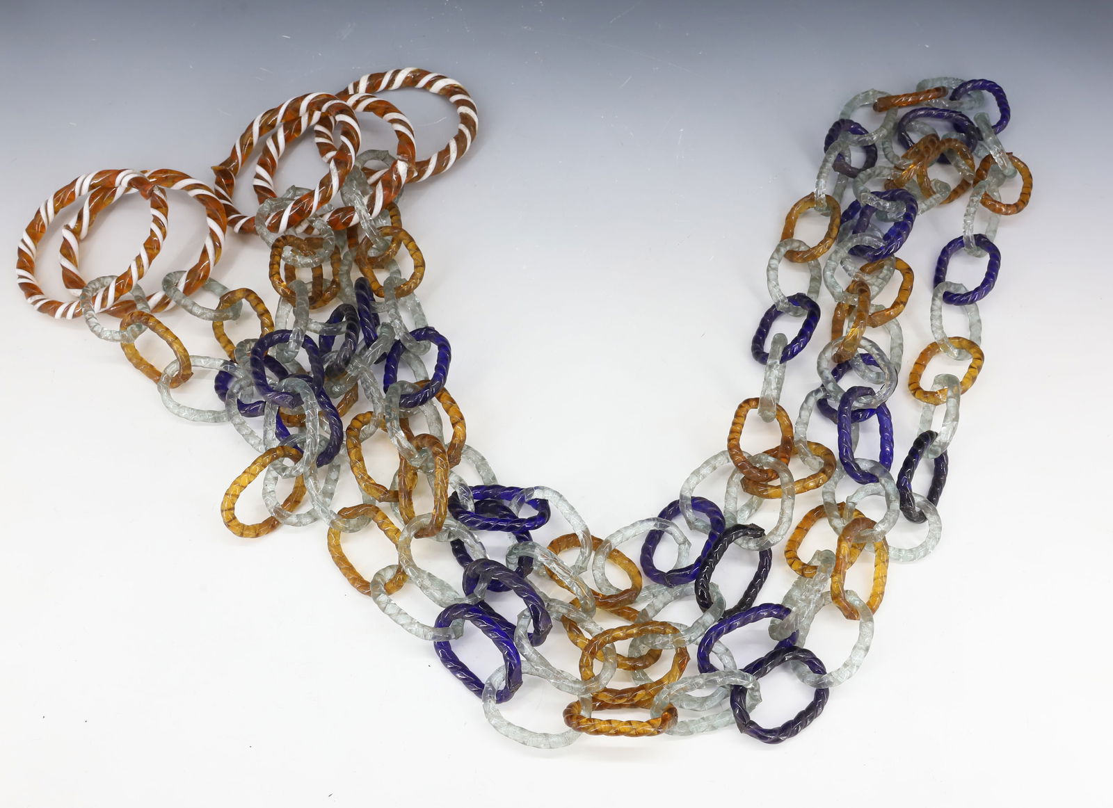 ANTIQUE GLASS CHAIN WHIMSEY: FIVE AMBER/WHITE RINGS ATTACHED TO COBALT/AMBER/CLEAR LINKS. 32" L. FROM RINGS. PLEASE READ CAREFULLY - SINCE THIS IS A COIN SALE PLEASE NOTE. ITEMS MUST BE PAID FOR THROUGH LIVE AUCTIONEERS OR WITH C
