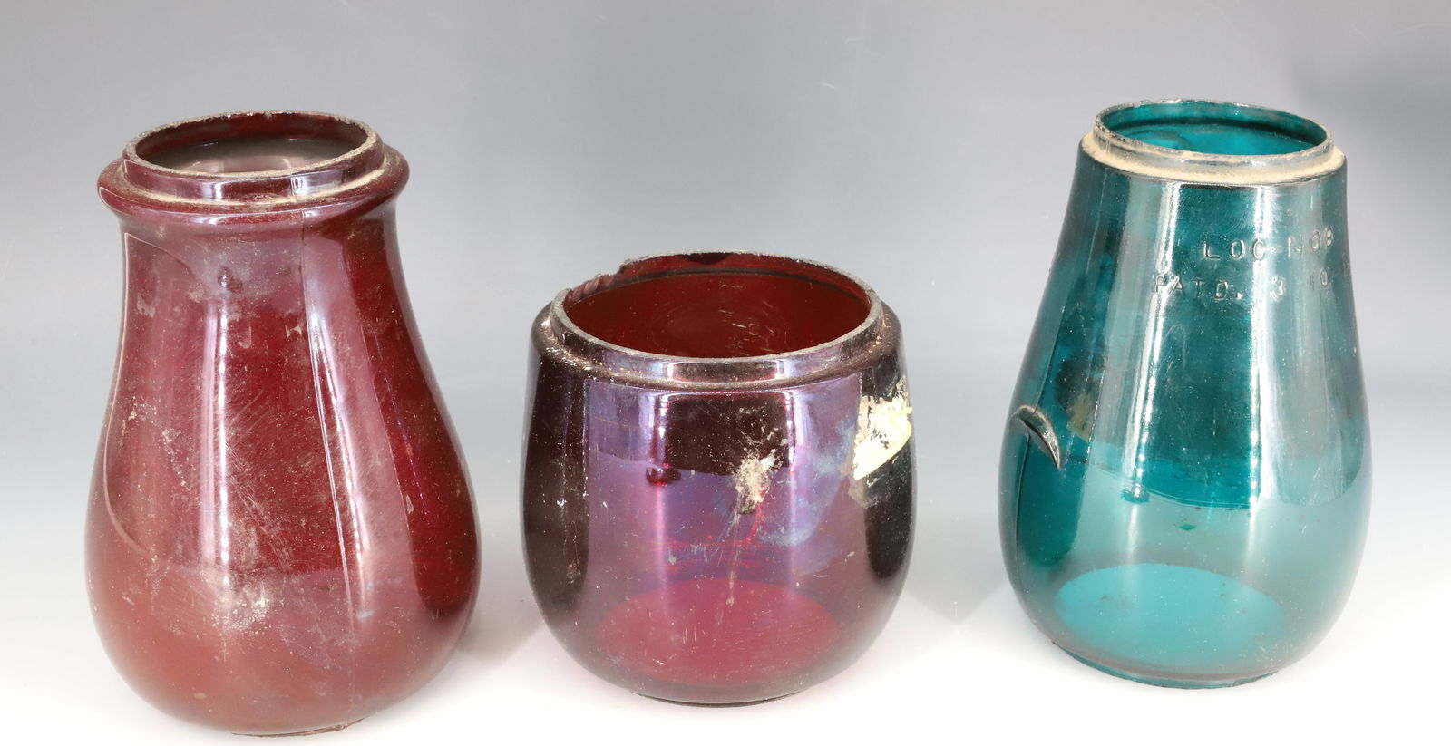 (3) KEROSENE LANTERN GLOBES: INCLUDING: DIETZ FITZALL, NEW YORK TEAL GREEN 6 5/8" H. (2 3/4" AND 3 3/8" TOP/BOTTOM FITTERS) WITH TWO RED 6 3/4" AND 4 5/8" HEIGHTS. PLEASE READ CAREFULLY - SINCE THIS IS A COIN SALE PLEASE NOTE. IT