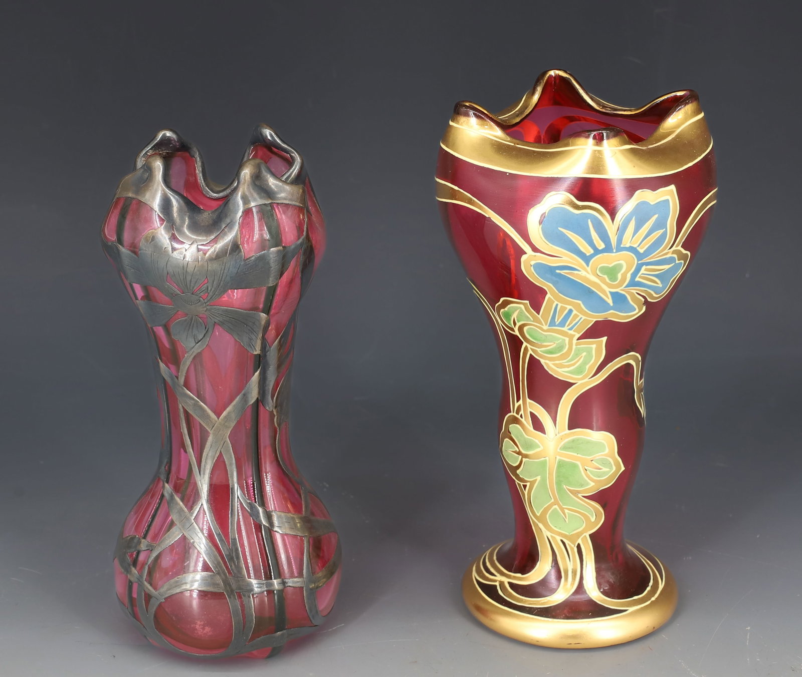 (2) ART NOUVEAU STYLE FLORAL VASES: CRANBERRY VASE WITH ENAMELED FLORAL DECORATION. SMOOTH PONTIL. 6 1/2" H. WITH, SILVER FLORAL OVERLAY PINK VASE WITH VERTICAL GREEN STRIPES. 6 1/4" H. PLEASE READ CAREFULLY - SINCE THIS IS A COIN SALE