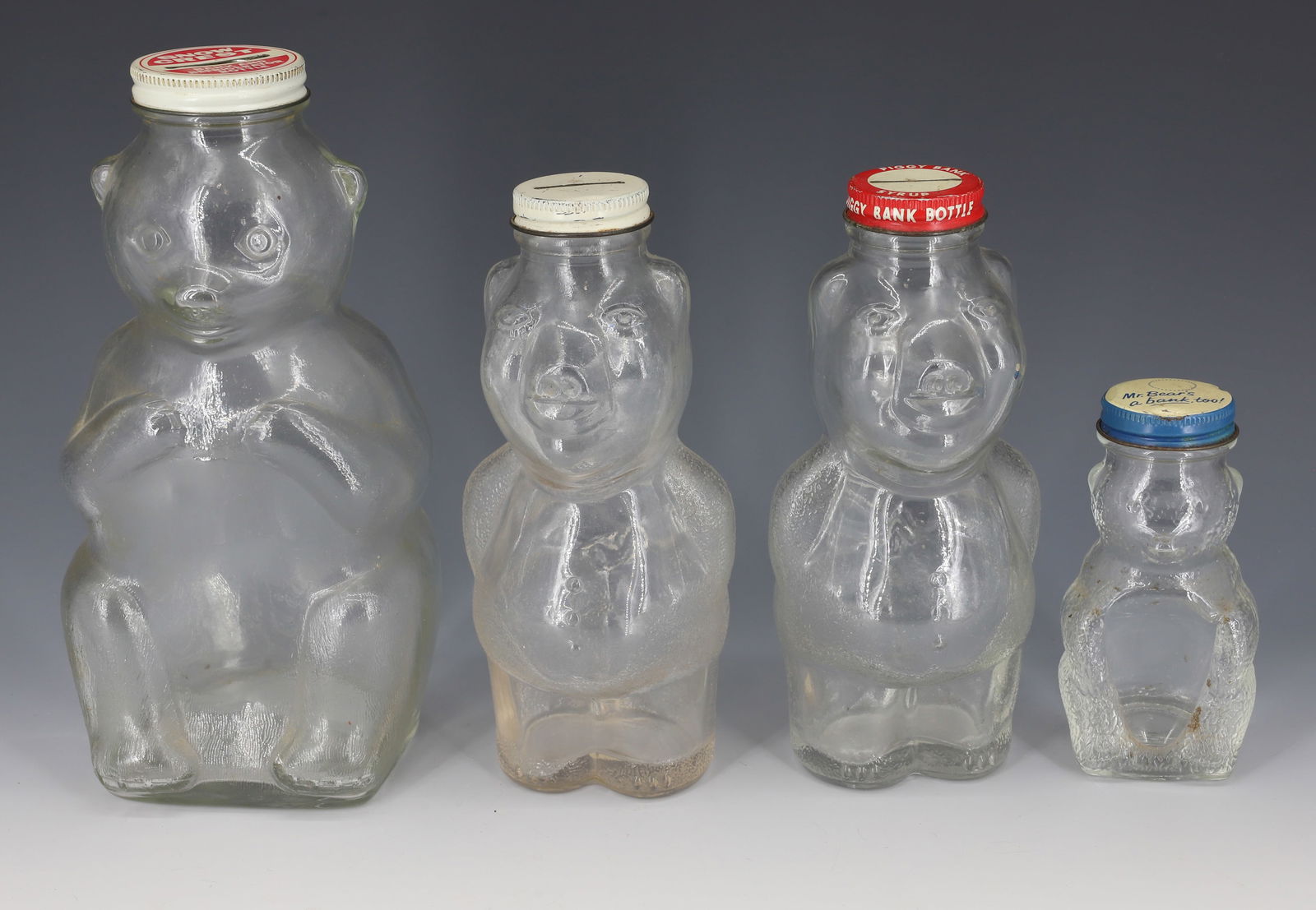 (2) BEARS AND (2) PIGS BANKS: LARGEST "SNOW CREST BANK AND REFRIGERATOR BOTTLE" 8 1/2" H. ONE PIG CAP MRKD. "PIGGY BANK SYRUP".